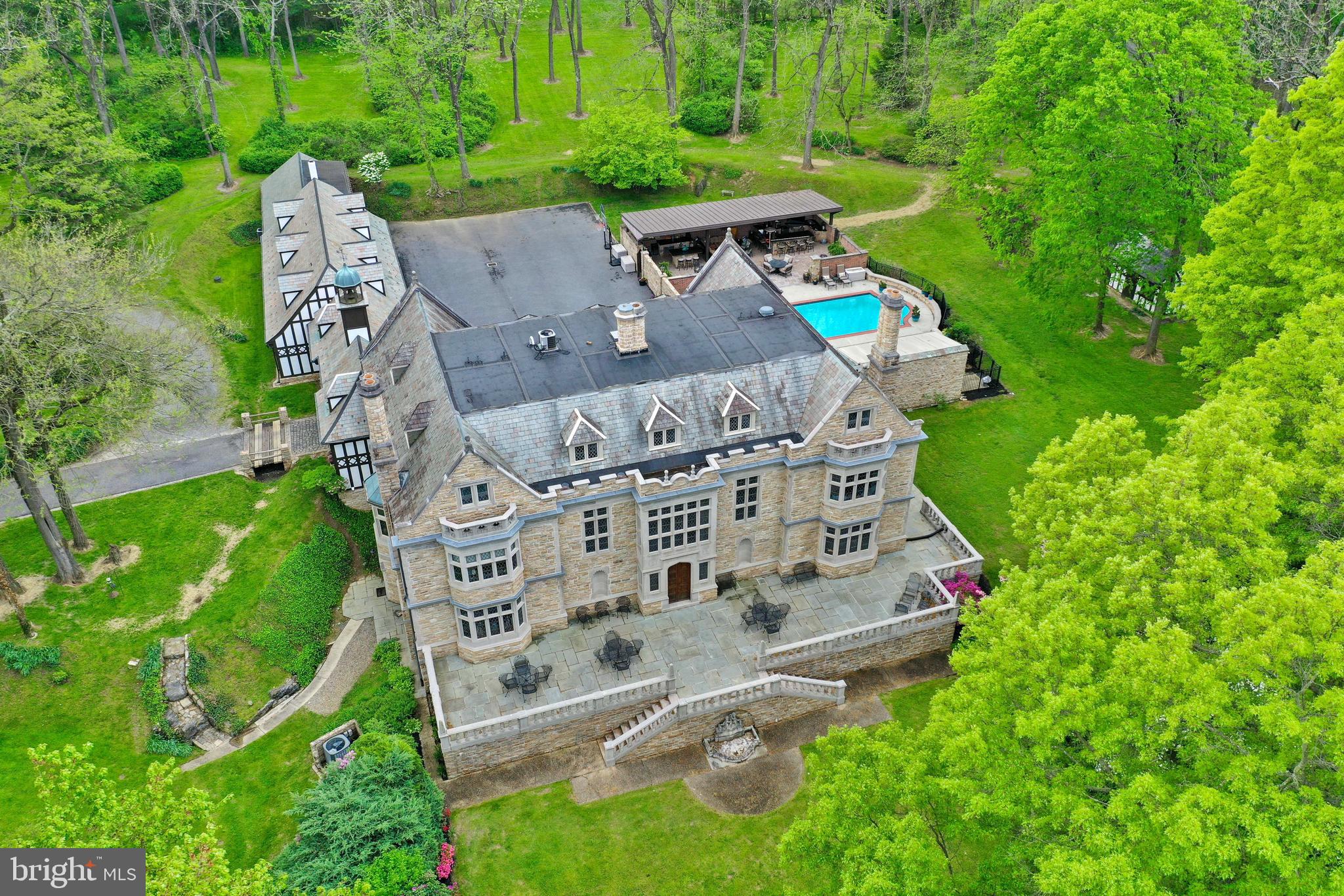 Welcome to Wyngate Manor! An elegant tree lined driveway leads to this magnificent castle-like estate that boasts 10 bedrooms, 7 full & 2 half baths, and over 10,000 square feet of living space on 4 levels. From the moment you step foot inside, you’ll feel as though you’ve been transported to England and stepped into a fairytale setting. Countless upgrades and amenities include an elevator that goes to each floor, high ceilings, marble floors inspired by the Hatfield House in England, detailed crown molding, French leaded glass windows, plaster ceilings, stained glass windows, and much more. The exterior is an absolute oasis that features an in-ground patio & pool area, a covered patio built for entertaining with multiple countertops, and a high-top bar with gorgeous hanging lights and TV. It also includes convenient access to a pool house with bath amenities. This resort-like setting is perfect for summer gatherings and relaxing under the sun at the comfort of your very own home. Also included on this property is 100 School House Rd, an income producing rental house, and a detached 6-car garage with a rented apartment on the second floor. This awe-inspiring home welcomes you with an incredible foyer that includes marble floors, detailed wood panel walls, 2-story coffered ceiling, and stairs leading up to the second floor walkway. Just off the foyer is a gourmet kitchen complete with all stainless steel appliances, exposed beams, tile floor, built ins, and pantry. A convenient laundry/mudroom is next to the kitchen and offers an ideal place to come inside after a rainy day or outdoor activities in the grass. Off the opposite side is a breakfast room designed with a bow window allowing the room to be bathed in natural light. Created for formal occasions, the dining room is a marvel. Past a set of French doors is the Great Hall—the centerpiece of this home. Countless details can be found such as a Tudor-style wood fireplace, floor to ceiling windows, a 2nd floor Minstrel Gallery (inspired by Berkeley Castle in England) overlooking the room, access to the scenic yard & pond area, and more. Past a lovely seating room with center fireplace and wood panels, you’ll find another wing of the house that includes an office, a living room that could be an additional bedroom with separate access to the foyer, a wet bar, and two sunrooms with access to the pool and patio area. Moving upstairs to the 2nd floor, you’ll find 6 bedrooms, one of which is the amazing primary suite with a spacious dressing area & built in, a bedroom with gorgeous views of the nearby pond, and a private bath featuring a walk-in tile shower and dual vanities.  The 3rd floor is home to 3 additional bedrooms, a full bath, large storage area, and a kitchenette with cooktop, sink, and mini fridge. The finished lower level makes entertaining a breeze with an incredible bar area featuring a hanging wine glass rack, wet bar, built ins, tile flooring, and exposed beams. Just off this area is a room currently used for fitness activities, with a concrete floor, coffered ceiling, and multiple closets. At the end of the hall, you’ll find a family room that could be easily converted into a home theater with storage closets on both sides. At the opposite end of the lower level is a rustic dining area with brick floors, wood fireplace, and exposed beams. There is also a bedroom with built-ins and a private bath. The exterior of this immaculate property is nothing short of astonishing. Enjoy your very own water views with a picturesque pond set to the backdrop of lush landscaping and surrounding trees. Entertain guests at the bar area next to the relaxing pool & patio. Play a game of tennis on your very own on-site court. Words truly cannot do this castle-like estate justice.  Conservation easement available upon request. Witness this once-in-a-lifetime property for yourself and schedule your showing today!