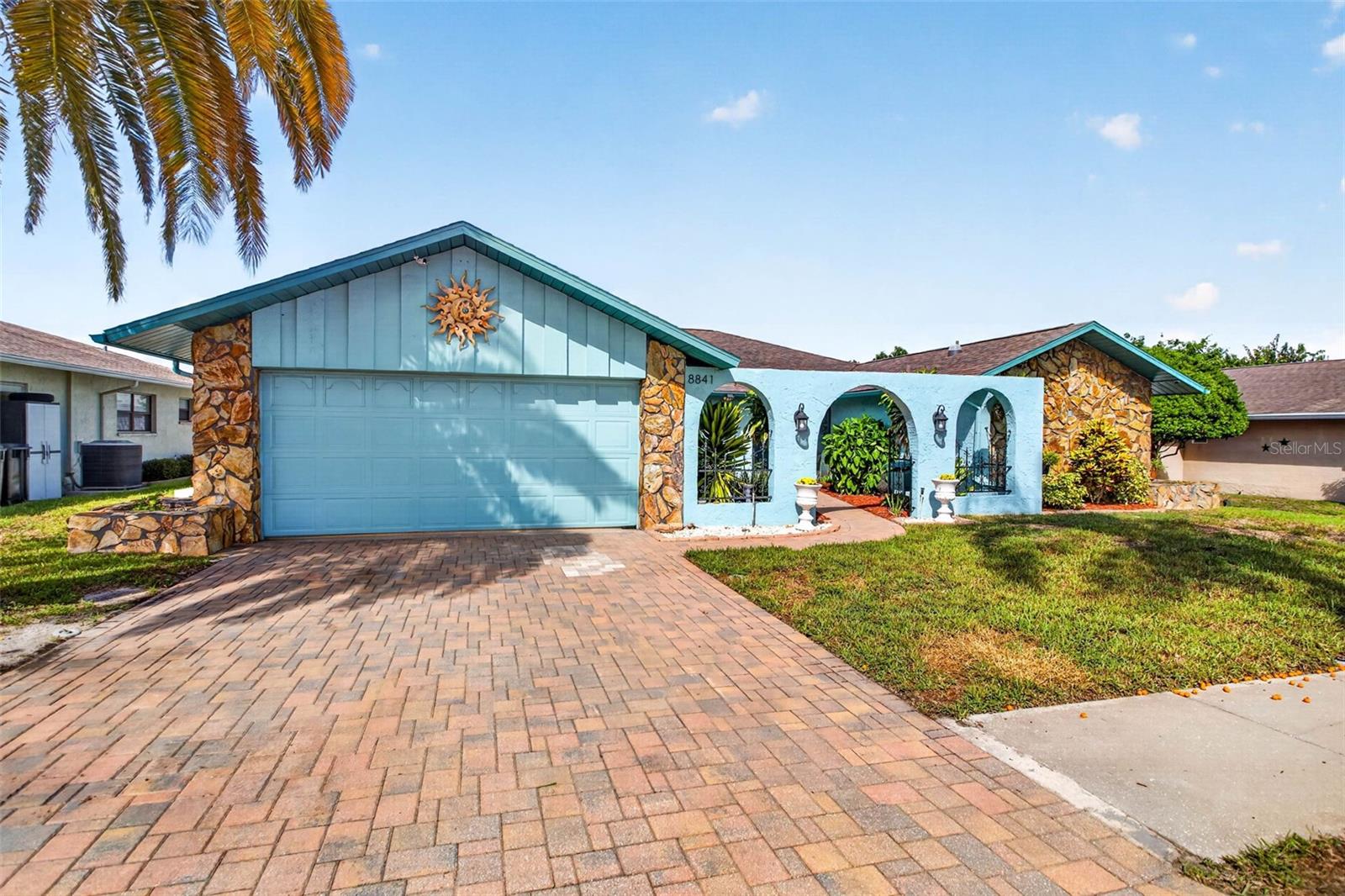 Welcome home to 8841 Andros Ln — where poolside living meets total freedom! Built high and dry, this pool home is tucked into a quiet, NO HOA pocket of Port Richey and comes with an option to assume a low assumable FHA loan for qualified buyers. This spacious 3-bedroom, 2-bath home delivers 2,033 sq ft of thoughtfully updated living space and a split floor plan built for both togetherness and privacy. Sunlight pours in throughout — thanks to the abundance of natural light plus skylights in both the kitchen and primary bathroom. The kitchen has plenty of cabinets, counter space, a roomy pantry, an oversized island with seating, and another eating area. The primary suite is a true retreat: an oversized walk-in shower, double vanity, and plantation shutters bring spa-level comfort to your everyday routine. Tile floors run throughout the common areas, and luxury vinyl plank flooring in the primary suite. Outside is where this home truly shines: a solar heated, screened-in pool and spa with a brand-new pool pump. Wait until you see the pool LED light show at night! This home is perfect for entertaining with the generous indoor living area and sliding glass doors that lead out to the covered patio and pool area.  Hurricane shutters on the covered patio area give you peace of mind throughout every season. Florida beaches and parks are less than 30 minutes away, such as Hudson Beach and Robert K Rees Memorial Park.  Minutes from major roads, shopping, dining, hospitals and outdoor recreation — this one checks every box. Pristine. Private. Priced to move. Let's get you in the door!