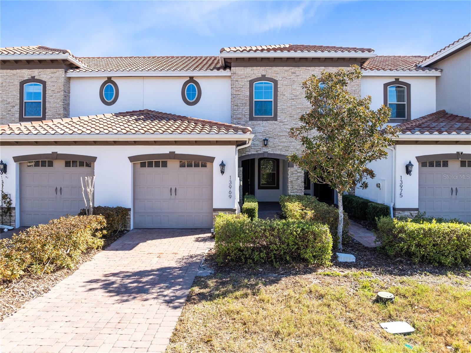Set in Eagle Creek Village at Lake Nona, this two story townhouse offers 2 bedrooms, 2 full baths, 1 half bath, 1,346 square feet, and a one car attached garage, all behind a 24 hour guard gated entrance with resort style amenities. Stone accents and a covered entry create a great first impression, then inside you will love the bright open layout with oversized tile floors, recessed lighting, and easy flow from living to dining. The kitchen is built for everyday life and entertaining with dark cabinetry, stone counters, stainless appliances, pendant lighting, and a large center island, plus sliding glass doors that open to a private paver patio with fencing, perfect for grilling and relaxing, with open green space just beyond. Upstairs, the primary suite feels like a true retreat with tray ceiling detail, a spacious walk in closet, and an en suite bath featuring dual sinks, stone counters, and a large walk in shower with modern tilework. The second bedroom also includes a walk in closet and its own en suite bath for added privacy, and the upstairs laundry keeps everything convenient. Enjoy Eagle Creek favorites like the modern recreation center, championship golf, tennis and pickleball courts, resort style pools, and scenic trails, all minutes to Lake Nona Medical City, dining, shopping, and major highways, plus a home warranty included for extra peace of mind.
