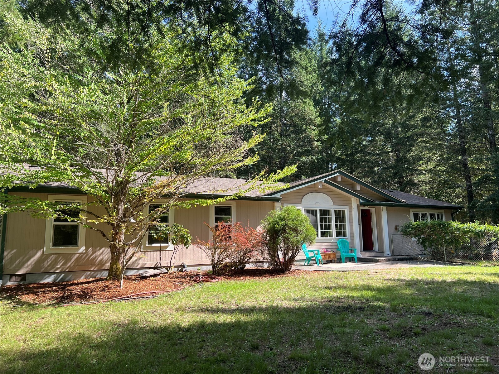 Discover your perfect 5-acre retreat in this delightful 3-bedroom, 2-bath mountain home, nestled peacefully off Hinkle Tinkle Lane at the end of the road. Surrounded by mature trees, this freshly painted, bright, and clean getaway offers a secure fenced area and beautifully landscaped grounds. Step inside to find a well-laid-out kitchen, perfect for culinary enthusiasts, alongside elegant hardwood and ceramic tile throughout. Enjoy modern comforts with high-speed fiber optic internet, ideal for both relaxation and remote work. Versatile outbuildings and plenty of room to build your dream shop! Just minutes from downtown Packwood and a short drive to Mount Rainier National Park and White Pass Ski Area. ~2.5 hrs from SEA or PDX