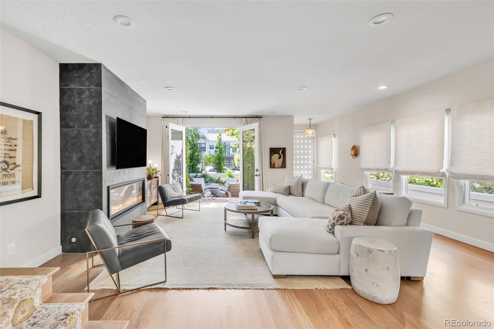 This exquisitely designed home in Cherry Creek North cannot be beat. Tucked on a quiet block in the heart of the neighborhood, just one block from world-class shopping, dining, and galleries, this immaculate end-unit luxury townhome lives like a single-family home with only one shared wall and no HOA. Extensively redesigned in 2021, with the exterior refreshed in 2025, the home showcases thoughtful upgrades and elevated finishes throughout with no expense spared. Inside, 4" stained white oak hardwood floors, custom stonework, designer lighting, and glass shelving create a sophisticated yet welcoming atmosphere. The dining area features custom folding doors that open to the side patio with a retractable awning, creating seamless indoor-outdoor living. The redesigned front patio with a gas fireplace offers an inviting space to relax or entertain. The chef’s kitchen is anchored by a 10' waterfall island, custom slab granite backsplash, illuminated white maple cabinetry, designer lighting, stainless appliances, and a coveted La Cornue range with custom vent hood. A built-in bar with wine refrigerator and ice maker makes entertaining easy. The spacious primary suite features vaulted ceilings, natural light, a fireplace, and a fitted walk-in closet. The spa-inspired bath includes heated floors, a floating vanity, soaking tub, and curbless walk-in shower with dual shower heads. The second bedroom or office features a Juliet balcony, custom closet, and renovated bathroom. The finished basement with 9' ceilings offers space for a media room, gym, or game area, plus a private guest suite with custom bathroom and steam shower. Additional upgrades include a tankless water heater, two high-efficiency furnaces, two A/C units, luxury window treatments throughout, a two-car garage with storage, and three additional private off-street parking spaces. An exceptional opportunity in one of Cherry Creek North’s best locations.