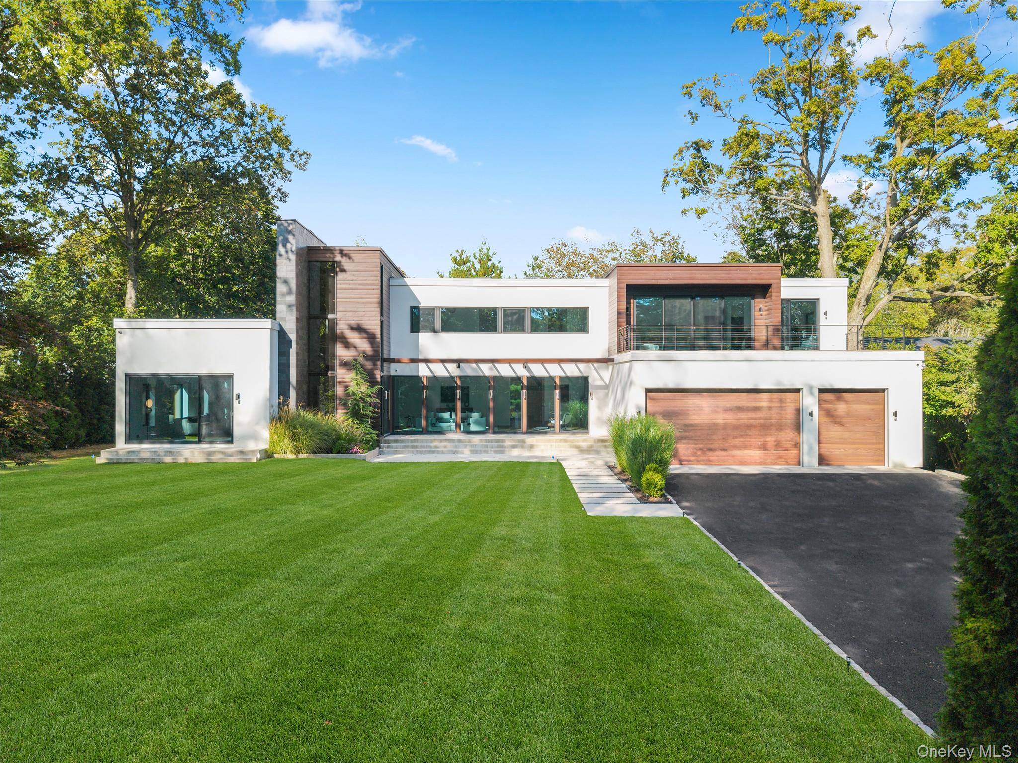 A new 2023 architectural beauty and one of the most extraordinary contemporary homes in the prestigious Orienta Point coastal community. This spectacular modernist retreat offers peace and privacy on a gated 0.7-acre oasis, just steps from the waterfront and Harbor Island Park, beach clubs, and only minutes to Village shops, restaurants, and Metro-North to NYC. Inside is pure elegance and simplicity - natural stone and wood accents with honey-hued floors, crisp clean lines, sky-high ceilings, and dramatic walls of glass that celebrate nature at every turn.

Every space is breathtaking - the two-story entry foyer, the sleek gallery-like living room and the custom-designed kitchen with 19ft waterfall island and top-tier appliances including an Italian Bertazzoni cooktop. From here, this great room extends into seamless indoor-outdoor living, opening to a fabulous deck, level backyard and an outdoor kitchen with a Medallion grill set beneath a pergola. This home offers everything you could desire - 3 fireplaces, a chic dining room, wet-bar, stylish powder room, large walk-in coat closet, striking family room with soaring ceiling and endless light. There’s an outfitted mudroom with access to the 3-car garage and side door, an oversized pantry and three serene bedrooms, all with ensuite baths. Upstairs, a wonderful central lounge room opens to a glorious sun terrace, plus two ensuite bedrooms, a large laundry, a 7th bed or flexible office and a full hall bath. The primary is simply exquisite with a wall of glass sliders to a private balcony, a sitting room, a luxurious ensuite, and a boutique walk-in closet for two. The lower level is ADDITIONAL 1300sf of bonus space that offers incredible versatility with access to the private, level backyard and outdoor kitchen with glass sliders to the rear. Unmatched!
