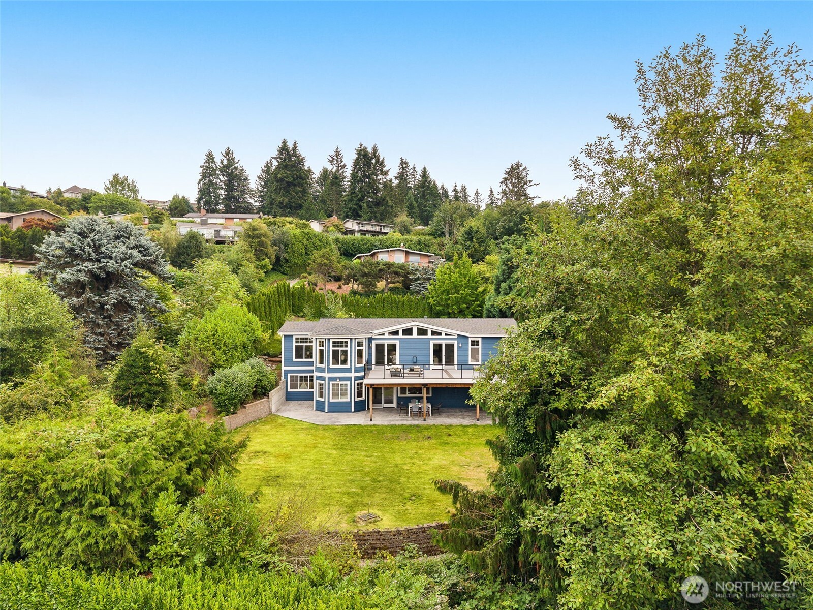 Prime Bellevue Luxury Estate! Enjoy your own personal, private retreat on more than a half an acre of land. This gorgeous 5 bedroom, 2.5 bathroom home in the highly desirable Hilltop neighborhood of Bellevue provides the perfect combination of luxury, privacy, and comfort. Tucked away on the hills at the end of a long driveway, the residence is surrounded by privacy trees amidst a lush, manicured lot. Be magically transported into quiet seclusion as you step into the home. Vaulted ceilings, beautiful premium LVP flooring, and an impressive stone fireplace enhance the warmth and spaciousness of the main living areas. Enjoy horizon views from a large deck newly built in 2022 overlooking the serene backyard. 100K lovingly poured into creating a backyard oasis. The chef's kitchen boasts granite countertops, newer appliances, and a huge pantry. The home also features a desirable main level primary bedroom with an en-suite 5-piece bath. Downstairs, you'll find 4 additional bedrooms and an oversized family / rec room that leads to an expansive patio and the backyard sanctuary. Newer roof, LVP flooring, ceiling lights, cooktop, double oven, fridge, and washer/dryer.  Conveniently located and only minutes from I-90, shopping, dining, parks, and top Bellevue schools, but feels a world away! Come check it out and see for yourself.