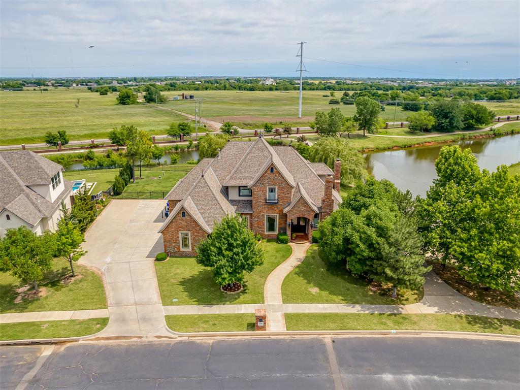 Fantastic location in the highly sought after Carrington Lakes!  The lot this home sits on has an amazing view of two ponds, walking trails, and is located catty-corner to the clubhouse and playground area.  There is only one neighbor located to the West, with an open lot and clubhouse to the South. Walking trails, ponds, and a greenbelt surround the East and North sides.  This home offers so much for a family with a formal dining room, breakfast nook, and a  kitchen with a large island, farm sink, large bar, a six burner Jenn-Air gas range, double ovens, and large pantry.  The living room offers large windows with a great view of the pool with a large waterfall.  Large built-in book shelves and gas fireplace are located in both the living room and office.  The oversized primary bedroom is located downstairs with French doors that lead out to the backyard.  The primary bathroom offers a large primary walk-in closet, walk-in spa shower, a champagne-bubble soaking tub to relax in, and a gas fireplace to enhance the mood after a long day of work.  Upstairs there are 3 bedrooms with one having a private full bathroom and large closet.  The other two bedrooms share a Jack and Jill style bathroom.  The 4th room upstairs is a bonus room that leads into a theater room with Epson projector, surround sound, and home theater seating. The back of the bonus room leads out to a walkout balcony that overlooks the pool, ponds, and walking trails.   
The backyard is breathtaking with a hot tub and a tranquil waterfall that flows into a pool perfect for hosting family gatherings.  At the ends of the waterfall are gas firepits to set the mood for a relaxing night swim.  The garage has a storm shelter providing peace of mind during spring storms.