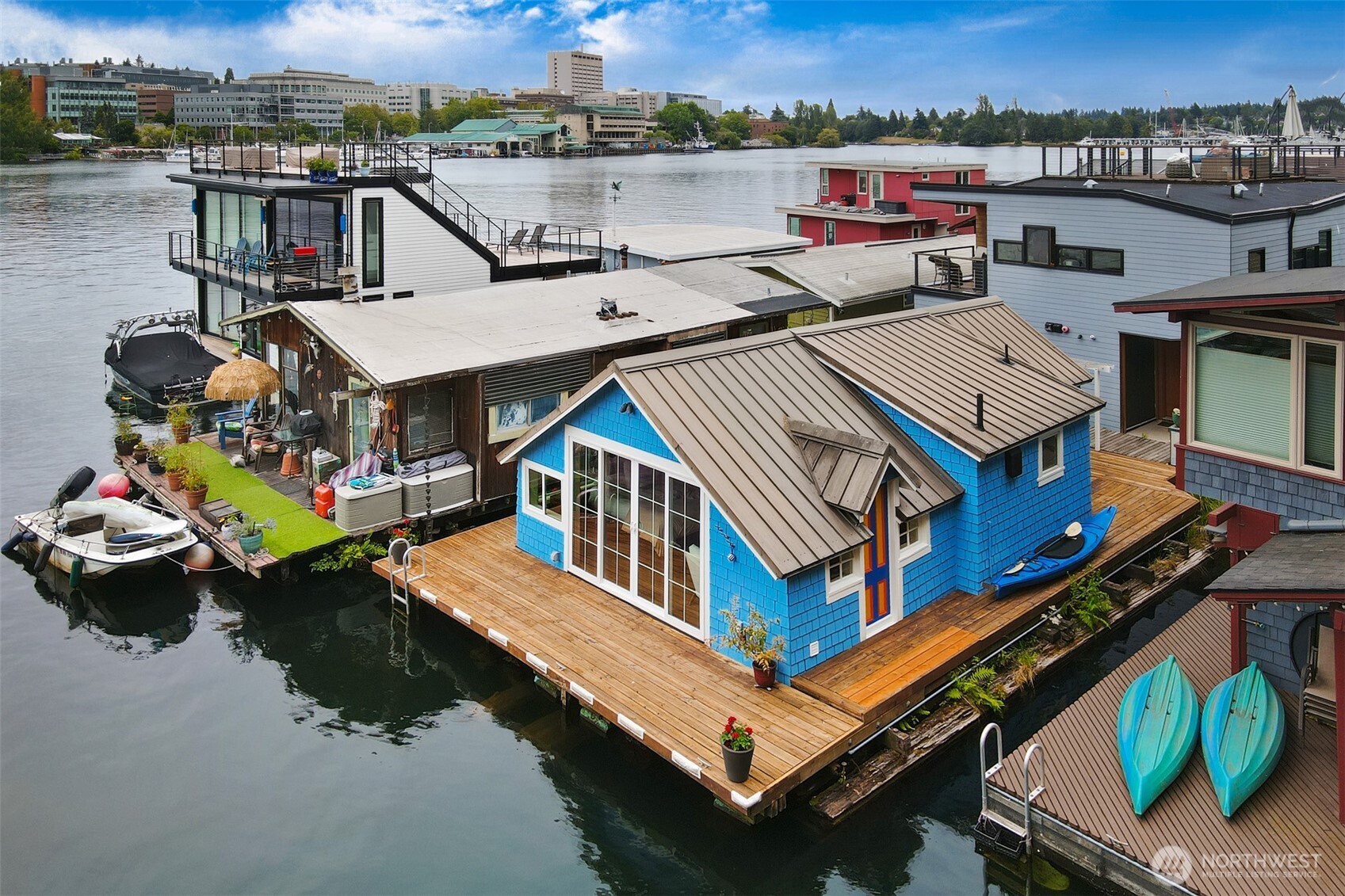 Once in a while, there is a home that makes you feel something pretty special. Maybe it's the memorable stories of the past and the enjoyment it brought to so many. Or perhaps it's the future opportunity of what it can give back to you.  Packing a punch is this incredibly adorable studio-size cottage, floating in Portage Bay since the 1940s and thoughtfully updated in 2012.   Periwinkle proud, adjacent to the widest channel in the bay with a setting beyond expectations. Vaulted ceilings stretch above; new flooring settles at your feet. Natural gas for heating, cooking, and the outdoor BBQ hookup.  One convenient parking space near the stairs. Generous 53 sq ft storage locker with three upper platforms — handy for swim gear, lake hobbies, or whatever floats your boat.