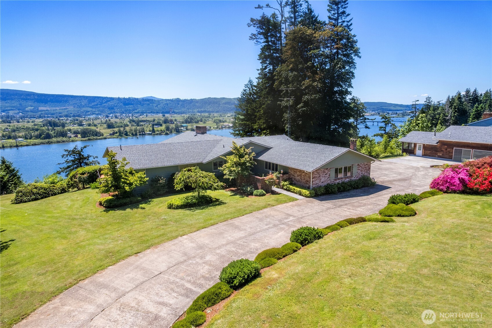 Absolute stunner set on nearly 4 acres across 2 separate parcels along the breathtaking Columbia River! At over 4,300 sq ft, this 4 bed/3 bath home is thoughtfully updated showing exceptional craftsmanship & quality finishes. Walk thru the Mahogany doors to gorgeous Italian title & solid Brazilian Teak floors to the incredible views. The main level features formal living & dining rooms, family room, primary bed w/ 5-piece ensuite, second bed & bath, 2 propane fireplaces (marble & stone), & laundry room w/ custom cabinetry. The gourmet kitchen offers abundant custom cabinetry, quartz countertops, & high end SS appliances. The lower level provides flexibility w/ 2 additional beds, including a second primary suite, double sided wood burning fireplace, bonus room, utility/storage space, & two additional sliding glass doors that open directly to the beautifully landscaped grounds. Additional highlights include custom updated windows & wraparound deck perfectly positioned to take in the spectacular riverfront setting. Not included in the home's square footage is an impressive 2,000 sq ft pool house featuring a 20' x 40' in ground pool, expansive pool deck, additional ¾ bath, & a new roof. Outside, enjoy a custom 2 story treehouse complete w/ electricity. Fruit tree orchard! 2 car attached garage & detached single car garage. This extraordinary riverfront estate offers the perfect blend of luxury, privacy, recreation, & natural beauty. Your own private oasis on the Columbia River!