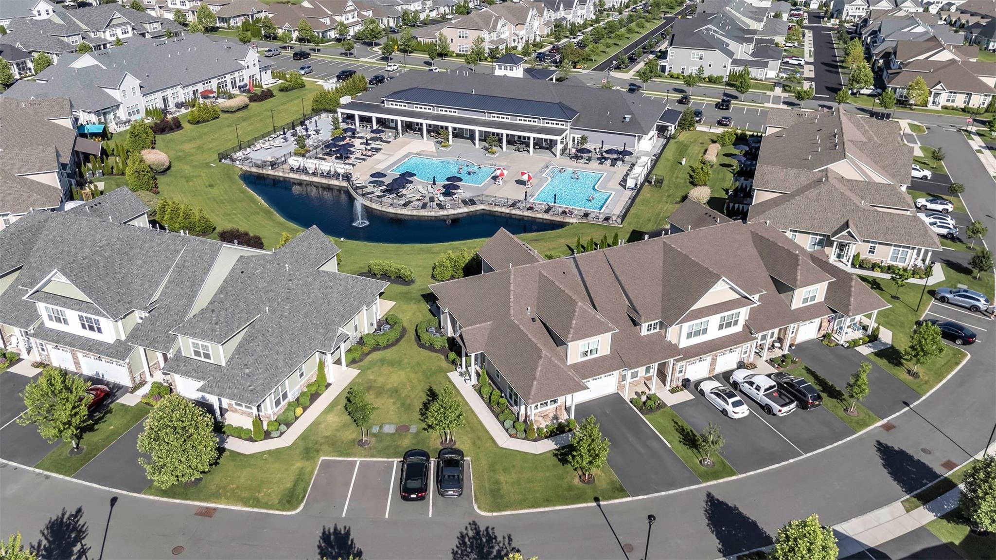 Welcome Home to this impeccably and stylishly designed 3 Bedroom, 2 1/2 Bath, Essex model End Unit, with views of the Pond, Fountain, Pools and Club House, located in the sought-after gated community of Country Pointe Meadows!! This unit is one of only a few that are NON-AGE restricted! This stunning condo WOWS from the moment you enter, and exudes discerning style, sophistication and elegance throughout!  This turn-key Residence offers the perfect blend of modern upgrades, low-maintenance living, and resort-style amenities. Step inside to find a bright and spacious open-concept layout featuring high, soaring ceilings, hardwood floors, and custom finishes throughout. The Chef's Kitchen is equipped with stainless steel appliances, a Kohler farm sink, Quartz countertops with an extended Quartz backsplash, custom Kitchen cabinetry with pull-out drawers and a custom pantry, ideal for both everyday living and entertaining. The Kitchen also features a window seat which was smartly integrated into the Kitchen area, to add both comfort and space. The gracious Dining Room flows seamlessly into the stunning Living Room, featuring a wall of windows and glass sliders, as well as a gas fireplace, providing additional ambience and warmth during those darker, cooler months.  The glass sliders off the Living Room lead directly to your private patio, where views of the Pond, Fountain and Pools add another layer of beauty and tranquility to your time spent outside.  Enjoy entertaining friends and family alike with a delicious meal on the grill! Back inside, the First Floor Primary Suite dazzles with a custom wood-beamed ceiling, designer finishes, dual closets and a stunning spa-like ensuite bath, featuring a fully-tiled shower with glass doors, dual vanities and anti-fog mirrors. There is also an attractive powder room on the first floor as well a separate laundry room. On the second floor, there is a spacious loft which doubles as a home office, as well as two additional Guest Bedrooms, one of which has its own custom window seat, ideal to take in the Pond and Fountain views. They are both generously sized and share a nicely appointed Full Bath with a tub. As if all this weren't impressive enough, the completely finished Lower Level is a DREAM COME TRUE!  It comprises a Media Room with an electric fireplace, which movie/TV buffs will fall in love with, a gym for fitness buffs, a bar perfectly tailored to accommodate your favorite bottles and wine collection, and a truly impressive, expansive "closet," which surely will accommodate your entire wardrobe and shoe collection!  Country Pointe Meadows is part of The Boulevard, a master-planned community that will offer a mix of residences, offices, retail shops, dining establishments, (Starbucks included!), medical facilities, open spaces and parks. Simply stated, you will have everything here at your fingertips, and so much more! Easy travel to/from NYC and other areas of Long Island.  Live the lifestyle you so richly deserve!  **Please note:  227 Belmont Circle will be available to close once the current Homeowners are able to close on their "under contruction" unit in Country Pointe Preserve.