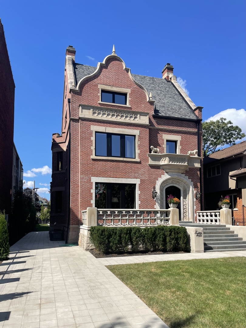 A Timeless Treasure in Kenwood - Where History Meets Modern Luxury.  After a meticulous two-year renovation, this historic urban estate once again shines in all its grandeur - an extraordinary blend of early 20th-century elegance and contemporary design, nestled on an expansive 50 x 300-foot lot in the heart of the Kenwood Historic District.  Originally built in 1904, J.B. Cole's residence was heralded by The Economist as "a picturesque structure in old English style of architecture," complete with ornamental iron doors, a sweeping circular staircase, and finely crafted finishes. Today, this architectural gem has been thoughtfully restored - honoring its storied past while seamlessly integrating the luxuries of modern living.  Regal stone lions still guard the original iron doors, which open to a dramatic foyer showcasing a paneled fireplace, built-in seating, and intricate stained glass. A grand, sweeping staircase - illuminated by a period chandelier - sets the tone for the magnificence within.  The main floor features reimagined open-concept formal living and dining areas, created by uniting the home's two original parlors. Pocket doors lead to a chef's dream kitchen, outfitted with stainless steel appliances, quartzite countertops, and generous space for  banquette seating. French doors open to a sunroom with access to a large deck, overlooking a beautifully landscaped, fully fenced backyard.  Upstairs, the curved main staircase (augmented by the original rear servants' stair) leads to a luxurious second floor anchored by the expansive primary suite - a private retreat featuring a custom walk-in closet, a marble-clad spa bath with a steam shower, and a sun-drenched, heated porch with views of the backyard oasis. Two additional bedrooms on this floor each include decorative fireplaces and share a tastefully updated bathroom.  The third level offers two generously sized bedrooms, each with custom closets and en-suite baths with steam showers - ideal for guests or family members seeking extra privacy.  Wide-plank wood floors and custom windows are found throughout, and the fully finished lower level is a home in itself. Heated with radiant flooring, this level features a spacious family/media room, a large laundry room, a fifth bedroom with walk-in closet, ample storage, and a wine cellar tucked beneath the front porch.  Enhancing the property is a Coach House, complete with a four-car garage and a spacious one-bedroom apartment above - perfect for guests, extended family, or additional rental income.  Ideally located near the University of Chicago, the Laboratory Schools, and all the dining, shopping, and cultural amenities the community has to offer - this is more than a home; it's a lifestyle.  A rare opportunity to own a piece of Kenwood history - exquisitely reimagined for modern living. Welcome home!