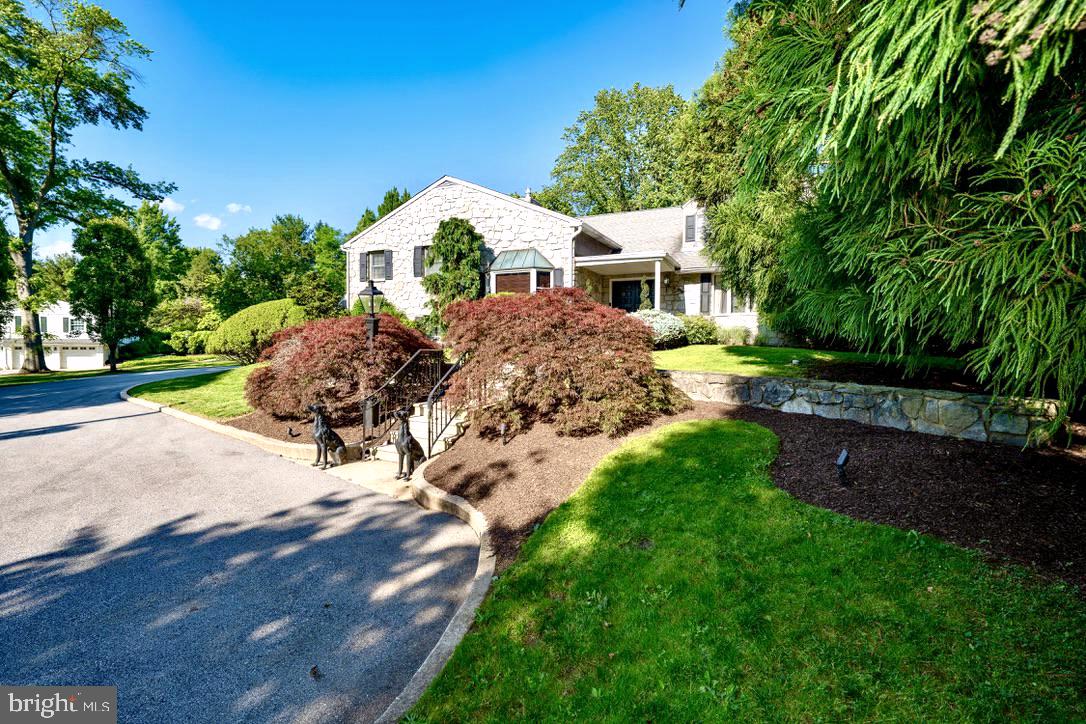 Welcome to 405 Boxwood Road, an exceptional and distinctive residence set at the end of a long, private drive on two beautifully manicured acres in the sought-after Beaupre section of Radnor Township. Offered for the first time since its original development, this remarkable property combines an uncommon sense of privacy with expansive views, thoughtfully designed living spaces, and an extraordinary array of amenities for both everyday living and entertaining.From the moment you arrive, the care and intentionality behind the design of both the residence and its grounds are immediately apparent. Spanning five levels, the home offers an impressive balance of formal and informal spaces, with generously proportioned rooms designed to accommodate everything from quiet living to large gatherings of family and friends.The main level welcomes you through a gracious foyer and features formal living and dining rooms, along with a chef’s kitchen that opens seamlessly to a breakfast nook and sunroom. The adjacent family room is an inviting gathering space and includes a custom bar complete with refrigeration, and sink. Also on this level is a versatile bonus room, beautifully appointed with custom woodwork and a gas fireplace, ideal for use as a private office, library, or den.The lower levels transform the home into an exceptional destination for entertainment. A spectacular custom bar, crafted from a reclaimed bowling alley, anchors the expansive entertaining room, while additional spaces include a game room, den, wine vault, and a second kitchen - particularly well suited to catered events and larger gatherings.The private primary suite is conveniently located just steps from the family room and offers a spacious bedroom with gas fireplace, a full dressing room that could readily serve as an additional bedroom, two walk-in closets, and a custom-designed bath featuring a stall shower, dedicated makeup area, and jetted tub. This level also includes a second bedroom suite with its own full bath, a loft, and hidden access to a versatile lower-level space.The uppermost level provides two additional generously sized bedrooms, a full bath, and a spacious sitting area, offering flexibility for family, guests, or additional private living space.Outside, the property takes full advantage of its extraordinary setting. A large stamped-concrete terrace provides an ideal setting for outdoor dining and entertaining, overlooking the in-ground swimming pool and outdoor kitchen. Mature trees, beautifully planted gardens, ponds, and meticulously maintained lawns create a private and tranquil landscape that feels remarkably removed from the everyday.An attached garage and detached garage provide parking for four vehicles, while the expansive grounds offer ample opportunity to further customize the property to suit your lifestyle.Currently presented in move-in condition, 405 Boxwood Road offers a rare opportunity to acquire a substantial and highly private residence in one of Radnor Township�����s most desirable settings, with the space, character, and versatility to make it truly your own.