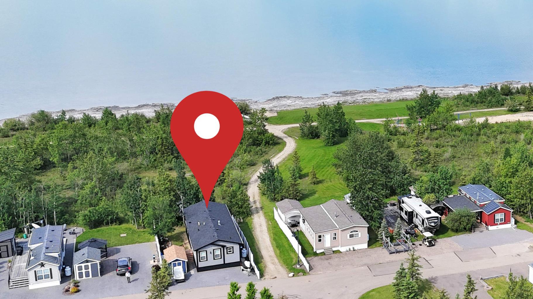 LAKEFRONT LOCATION | STEPS TO THE BEACH & PLAYGROUND | TURN-KEY VACATION HOME ~ This is the one you've been waiting for—your fully equipped summer getaway in DeGraff’s Resort on the east shores of Gull Lake! Just steps to the sandy beach and playground, this lakefront 3-season modular home is loaded with extras and ready for immediate enjoyment.~ Included: boat lift, boat slip, golf cart, Sea-Doo—and the option to purchase fully turn-key with furniture, housewares, paddle board, kayak, and more.~ Built in 2021, this modern and low-maintenance home offers a smart layout with an open-concept kitchen, dining, and living area that flows onto a covered 8x20 ft deck—perfect for summer BBQs or relaxing in the shade. ~ The primary bedroom includes a walk-in closet and private ensuite, with a second bedroom, 4-piece bath, and a flex room/office that can be used as an extra sleeping space.~ Central A/C keeps things cool on hot summer days, while the backyard offers private views of mature trees and a natural pond—your own peaceful retreat. ~ DeGraff’s Resort is a gated, family-friendly community with outstanding amenities: Private boat launch ~ Walking trails and natural green space ~ Horseshoe pits, pickleball & basketball courts ~ Two playgrounds, in-ground trampolines, and year-round washroom/shower facilities ~ Whether you're seeking the perfect summer basecamp or a low-stress, high-fun lifestyle at the lake, this property delivers exceptional value and lifestyle in one of Central Alberta’s most desirable resort communities.