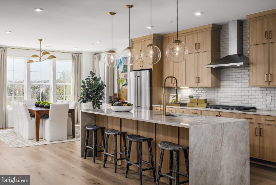 Discover contemporary elegance and everyday convenience in the Walney, perfectly situated just a short walk from the Ashburn Metro Station. This 3 BR, 2.5 BA, 1 car garage home is set within a dynamic community offering premier amenities—including a resort-style pool, cutting-edge fitness center, sophisticated clubhouse, and playground—this home delivers the ideal blend of lifestyle and location.  Designed with a modern farmhouse aesthetic, this home features curated finishes and designer details throughout. The gourmet kitchen impresses with warm wood-toned cabinetry, quartz countertop and backsplash, an alternate kitchen island with extra storage space, and bronze hardware. Professional-grade KitchenAid stainless steel appliances make this kitchen as stylish as it is functional. The upper level showcases a serene primary suite with a tray ceiling, generous walk-in closet, and spa-inspired bathroom with a dual-sink vanity and oversized shower. The primary suite also features a bump out bay window, perfect for an additional seating area. A convenient laundry room adds thoughtful touches with Whirlpool front-load washer and dryer, upper cabinetry, and a utility sink with quartz counters. The expansive North facing rooftop terrace provides the ultimate outdoor retreat—perfect for entertaining, dining under the stars, or enjoying quiet moments with panoramic neighborhood views. Additional features include an open oak staircase and wide-plank luxury vinyl flooring throughout.  Experience refined living and unbeatable access to the Metro in one of Ashburn’s most desirable, amenity-filled communities.