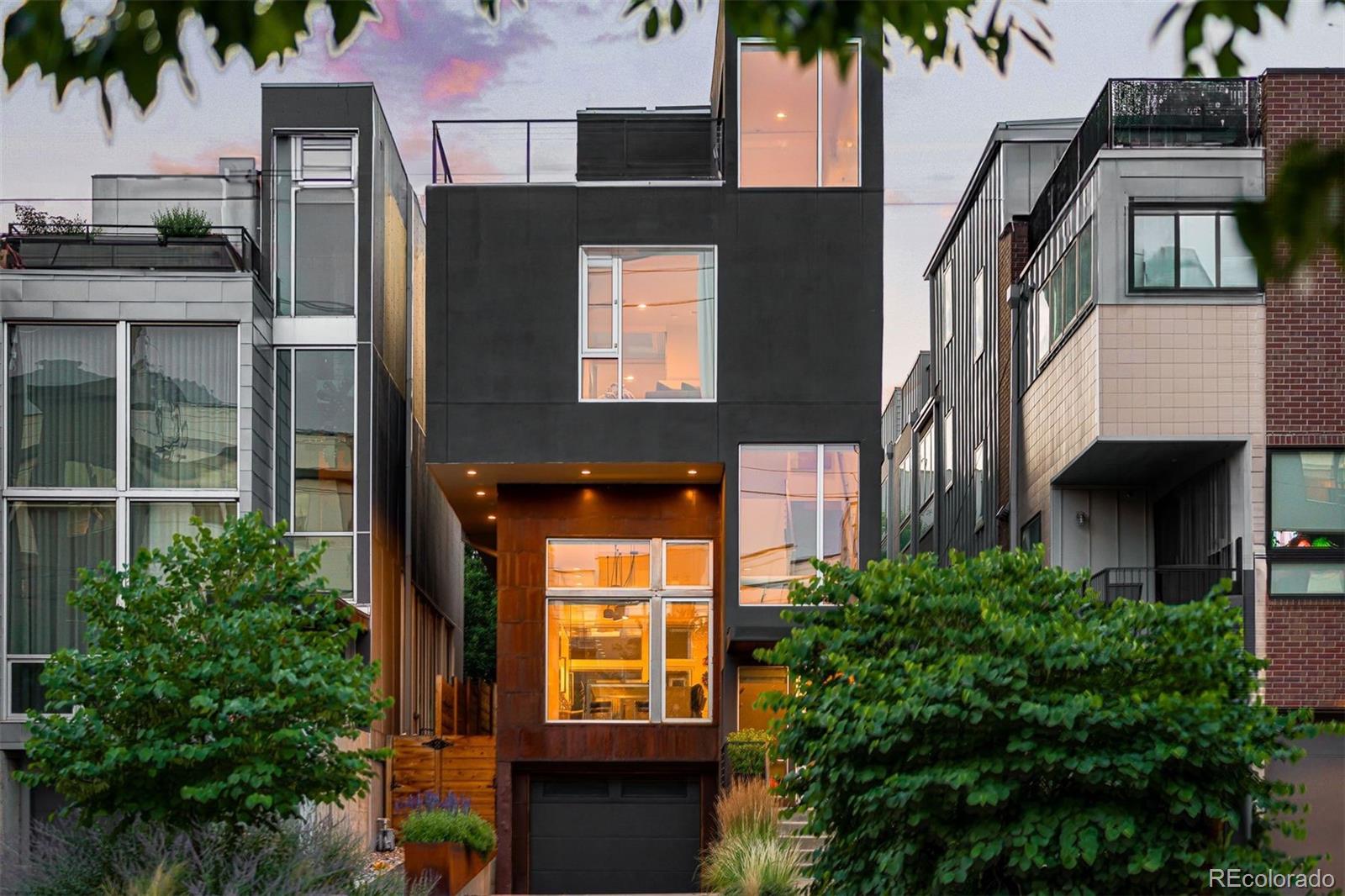 Located in the heart of Denver’s Lower Highlands, 1815 Boulder Street is one of two seminal architectural homes that helped catalyze LoHi’s evolution. Set among award-winning restaurants, coffee shops, boutiques, parks, and direct pedestrian bridge access to Downtown Denver, this single-family residence features a magazine-worthy backyard in one of the city’s most vibrant neighborhoods. A dramatic front porch with sweeping overhang offers a welcoming arrival, complemented by raised garden beds in front/back yards. Inside, the main level is filled with natural light from soaring ceilings and storefront-style windows, creating spaces that feel more gallery than residence. The eat-in kitchen is designed for daily living and entertaining, featuring integrated refrigerator and freezer columns, a waterfall concrete island with built-in wine storage, and open shelving. The dining area is anchored by statement lighting and custom built-ins, with lush front yard views, while the living room opens to custom bamboo-lined courtyard, extending indoor-outdoor living and connecting to a main-level bedroom. Main-floor bedrooms offer flexibility, including one currently used as an office with custom built-ins. Both share a remodeled Jack-and-Jill bath, complemented by a dramatic powder room. A separate staircase leads to an additional upper-level bedroom, creating separation from the primary suite. The primary suite lives like a private level, featuring a custom walk-in closet and refreshed bath with soaking tub, dual vanities, and steam shower, connected by a striking glass bridge to a private living area. The top-floor loft opens to a wraparound rooftop deck with sweeping city views. The backyard, a six-figure redesign by Designs by Sundown, offers a sculptural outdoor retreat. An oversized 2-car tandem garage with 600+ SqFt of storage and private driveway complete the home. Moments from Avanti and Michelin-recognized Alma Fonda Fina, 1815 is a one-of-a-kind work of art.