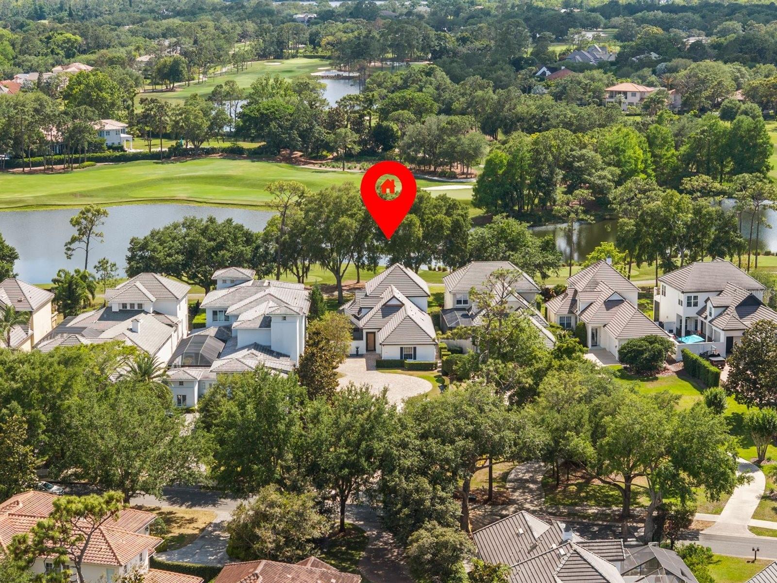 Wake up to serene wide-water views and wind down with striking sunsets over the 4th hole of Lake Nona Golf & Country Club. Ideally positioned to capture the scenery while set safely back from play, this residence offers a front-row golf course lifestyle balanced with privacy and ease. Nestled within one of the world's most celebrated private club communities, residents enjoy access to a Tom Fazio–designed championship course celebrated for its strategic layout, pristine conditioning, and enduring playability. It’s a course members and guests never tire of—rewarding and enjoyable for players of every skill level. Designed for effortless indoor-outdoor living, two sets of LaCantina accordion doors extend the home’s main living spaces to the courtyard pool and expansive screened lanai, creating a seamless connection between inside and out. Natural light fills the interiors, emphasizing an inviting layout suited for relaxed everyday living and comfortable entertaining. The screened lanai provides a shaded vantage point overlooking the golf course, while the private courtyard pool offers a quiet retreat for cooling off and unwinding in privacy. The spacious kitchen blends clean, modern style with everyday functionality, featuring ample cabinet space, sleek countertops, and a suite of Bosch appliances, including double ovens, an induction cooktop, and a dishwasher, along with a built-in wine fridge. This well-appointed space supports both casual dining and effortless entertaining. Thoughtfully designed for livability, the floor plan includes four bedrooms and 3.5 baths, with a flexible half bath that can be converted back to a full bath if desired. Upstairs, the primary suite includes dual closets and an adjoining den—ideal for a home office, reading lounge, or personal retreat. Step out onto the large private balcony to enjoy elevated views across the water and fairway, creating a picturesque setting to start or end each day. A generous secondary bedroom upstairs features its own ensuite bath and walk-in closet, while two additional bedrooms on the main level offer flexibility for guests.   The nearly half acre lot carries meaningful long-term potential - whether to expand the existing residence or build a larger custom  home.   The home's positioning well back from the road offers a distinct sense of arrival along with enhanced privacy, all framed by low-maintenance landscaping designed for easy living. Enjoy the convenience of a golf cart lifestyle with direct access to the club’s exceptional amenities, including golf, racquet sports, fitness, dining, and a vibrant calendar of social events. Here, luxury meets community within one of Central Florida’s most sought-after private enclaves.