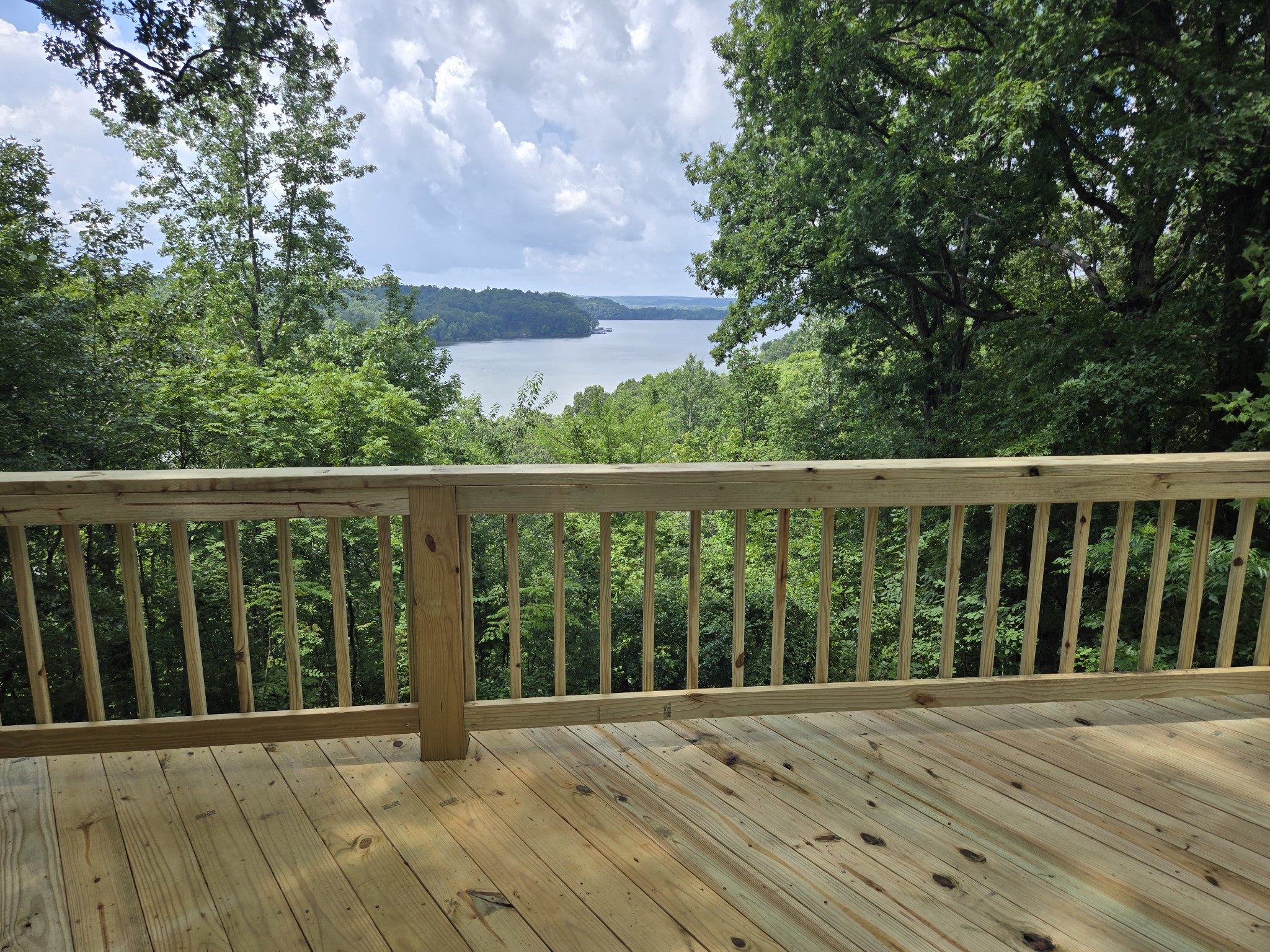 NEW DECK OVERLOOKING TN RIVER/KY LAKE ! AWESOME LAKE FRONT HOME!!! Charming 4 Bedroom, 2 Bath home on 5.11 surveyed Private acres. Home has 2 stories with a full basement. Home and Land fronts TVA, Permit for Boat Dock/Ramp with Permission. Totally furnished, just bring your clothes. Home would make a Great Air B&B, or your forever home with pool table in walk-out Basement along with garage and work area. NEW WELL PUMP 7/2025. NEW Gutters 7/2025. Small barn in the back, plenty of area to turn park your boat/cars . This is a unique piece of property with lake front, lake views and 5.11 acres for your privacy. Roof was replaced in 2022, and HVAC on main level in 2022. Contact us today for your Private showing. New Deck is being completed July 2025.