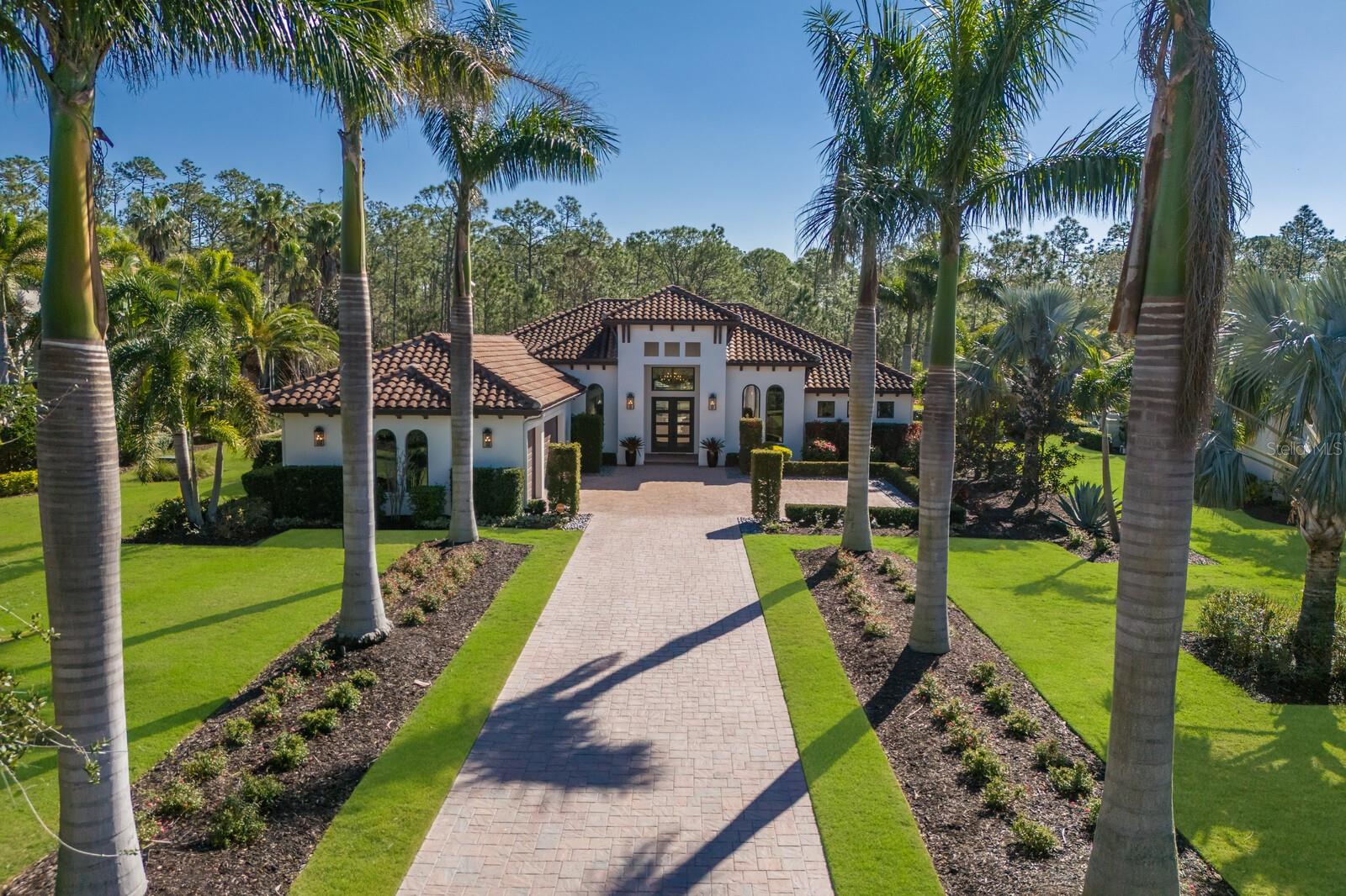 Under contract-accepting backup offers. Make your way down the long paver drive lined by dramatically uplit Royal Palms and meticulously manicured grounds that stretch across more than three-quarters of an acre. 19424 Ganton Avenue stands in the distance, a masterpiece of design and luxury, framed by the towering presence of Florida pines and ancient 200-year-old oaks in the backdrop. This stunning contemporary home is filled with the finest finishes yet has comfort and family in mind. The grand room makes a statement from the moment you enter with soaring ceilings, professionally styled interiors, custom trim work, built-ins, crown mouldings, a linear fireplace, and bespoke lighting. 10-foot-high by 22-foot-wide pocket sliding doors offer an unobstructed view of the nature outside. Impact glass protects the entire home from the outside world, but within, the ambiance is filled with tranquility and refinement. The gorgeous kitchen makes a statement in this residence boasting gas Thermador appliances, fine custom cabinetry with soft-close drawers and pull-out shelves, dramatic quartz countertops, and a massive island which serves as a gathering spot for family and friends. Glass-front cabinets illuminate from within to showcase your family's most important pieces and a 10-foot-tall glass-enclosed dual-sided wine display, is a showpiece that reveals your carefully selected vintages. Throughout the house, every detail is a testament to the homeowners' desire for perfection.  The primary suite is a luxurious retreat with access to the lanai, two custom-organized walk-in closets, a spacious marble vanity, crown molding, a large pass through shower, and a free-standing tub. The office features tall arched windows, high ceilings, and glass doors. Each of the two guest bedrooms have generous closet space and en-suite bathrooms. The bonus room, just off the great room, opens directly to the expansive covered lanai, where the true luxury of this home comes to life. The travertine deck stays cool in the late afternoon sun and surrounds a salt water pool and spa. The substantial summer kitchen—equipped with a granite-topped island, Blaze professional grill, Marvel outdoor fridge, prep sink, and a massive vent hood—welcomes outdoor dining and entertaining. It is in the tranquility of the fully fenced backyard, however, where the true drama unfolds. The serenity of the surroundings, the beauty of the perfectly curated landscape, sculpted hedges, and the majesty of the unspoiled 60+ acre forest all combined to create a rare kind of peace that is not easily obtained.  Bordering Lakewood Ranch, residents of the Concession enjoy all of the activity in and around the area but enjoy no CDDs, more spacious estate lots, a high security guard gate, and optional membership to the Concession Golf and Country Club. The Concession was home to the 2021 PGA Tour World Golf Championship and the 2023 PGA World Champions Cup, is the selected host of the 2026-2028 Senior PGA Chamionships, and is known as one of the most prestigious golf communities in the country .