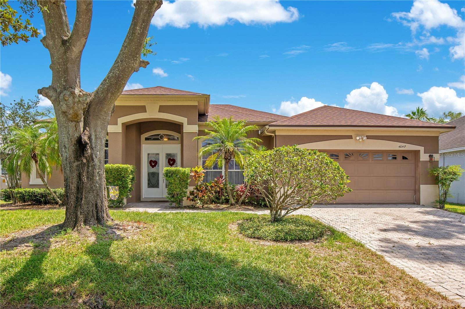 With charming curb appeal, no rear neighbors, and a peaceful water view, this 4-bedroom, 4-bathroom pool home offers the perfect blend of space, privacy, and outdoor living in the sought-after community of Gatlin Gardens. A new welcoming paver driveway (2025), new roof (2024, new A/C (2024), mature landscaping, and a covered front entry set the tone for what’s inside. Step through the front door and you’ll find a spacious, thoughtfully designed layout with gorgeous travertine flooring throughout and fresh interior paint (2024) highlighting the multiple flexible living areas, including a formal family room off the foyer, a dedicated dining room, and a large living room anchored by French doors that flood the space with natural light and frame the tranquil backyard view. The open-concept kitchen is the heart of the home, featuring granite countertops, a center island, breakfast bar, built-in desk with overhead wine rack, and a breakfast nook that looks out over the pool—perfect for both entertaining and everyday living. Tucked away for privacy, the generously sized primary suite offers private access to the lanai, a walk-in closet with new laminate flooring (2024), and a large ensuite bath. On the opposite side of the home, you’ll find three additional bedrooms and three full guest bathrooms, including a Jack-and-Jill, and one bathroom with direct pool access—so no wet feet tracking through the house. Out back, your private oasis awaits. A screened lanai with covered patio provides space for outdoor dining, while the sparkling pool invites you to unwind and enjoy the peaceful pond view just beyond the fenced yard. Additional upgrades include a new wood flooring in the laundry room (2024), new toilets in the primary and Jack-and-Jill bathrooms, new garage door motor (2023), lanai screened porch, (2024), new stove (2024), and new pool pump and filter (2025). Zoned for Boone High School (Go Braves!) and ideally located in a quiet, established neighborhood with easy access to top-rated schools, parks, shopping, dining, and major roadways. Just minutes from Waterford Lakes, UCF, and the 417, you’re never far from everything Orlando has to offer - this home checks all the boxes.