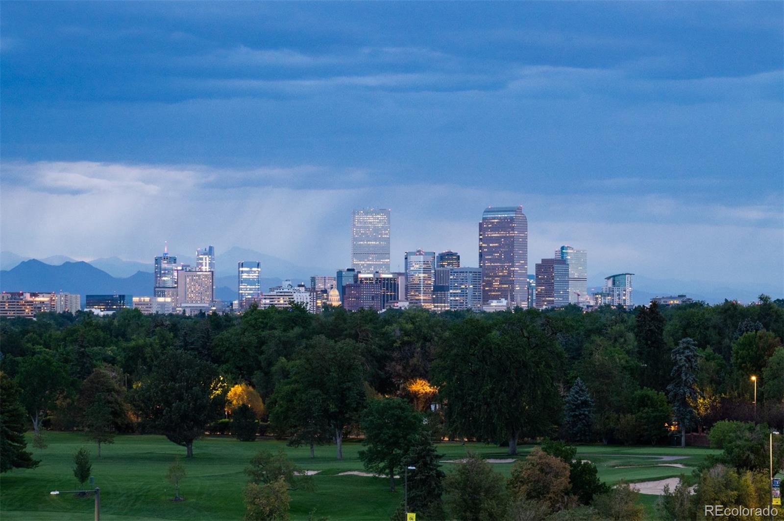 Crowning Cherry Creek's most exclusive addresses, this penthouse offers over 5,000+ square feet where the creek below and mature trees along its banks lend unexpected serenity to city living — a home of presence, craftsmanship, and privacy paired with views seldom equaled in Denver. Enter a marble-clad foyer, black herringbone underfoot, light dancing from a trio of sculptural chandeliers. A dramatic double-sided fireplace divides the entrance from the grand living room beyond, where walls of glass rising  to the ceiling frame sweeping views of the Denver Country Club golf course, the Front Range, and the city skyline. Three private terraces extend the living experience: one off the primary suite, a room unto itself for quiet mornings and starlit evenings; one off the kitchen and dining area, perfect for al fresco entertaining; and one off the guest suite, blurring indoors and out. The kitchen showcases culinary mastery appliances such as La Cornue range, 2 Cove dishwashers, Subzero refrigerator/freezer/wine cooler and ice makers, Wolf microwave, quartzite countertops, adjacent wet bar, sunlit breakfast nook, and a modular island seating six. The adjacent dining room, anchored by a crystal chandelier, sets an elegant tone for gatherings large and small. The expansive primary suite offers a sitting area, couture dressing room, and spa-inspired bath with soaking tub, dual vanities, and steam shower, with a personal gym just off the bedroom. A split wing layout boasts an intimate private guest suite with full ensuite bath and walk-in closet. Steps away, a versatile bonus/bedroom with Murphy bed enhance the residence.  The architectural threshold guides you to a bespoke library and executive office. Building amenities include true valet service, 24-hour concierge, manicured gardens, 4 car spaces with underground parking, and on-site car wash. With fairway, city and mountain views as its backdrop, this is a rare opportunity in one of Denver's finest addresses. See Video