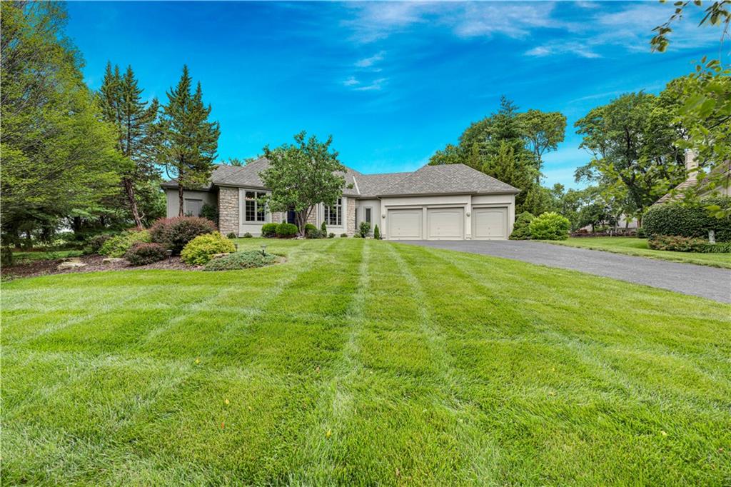 A great opportunity in the lifestyle community of Loch Lloyd, this reverse 1.5-story estate, perfectly situated on a nearly half acre cul-de-sac lot offers a premium setting with two patios overlooking serene greenspace. The stately front elevation with a brick front porch and columns sets the tone for this custom built home. Designed for effortless main-level living, the thoughtful floor plan features both the luxurious primary suite and a rare second main-level bedroom, plus a dedicated private office. Step into the heart of the home, where an open kitchen boasts a large center island and is open to a cozy hearth room. Entertain with ease in the spacious living room, complete with a convenient wet bar, or transition outdoors—enjoy your morning coffee on the private patio off the primary suite, and grill tonight's dinner on the patio right off the kitchen. The primary suite serves as a true sanctuary, anchored by a see-through fireplace connecting the bedroom to the spa-like bath. The daylight lower level expands your living and entertaining space, featuring a large family room with see-through fireplace, full bar, a full bath, an additional bedroom, plus a non-conforming 4th bedroom. A large amount of unfinished space in the lower level (approx. 41X24) offer flexibility for more living space or storage. New CertainTeed Grand Manor roof 3/26, whole house exterior paint 5/26, 1st Floor ceilings painted 5/26. Embrace the ultimate resort-style lifestyle in Kansas City’s premier gated community.