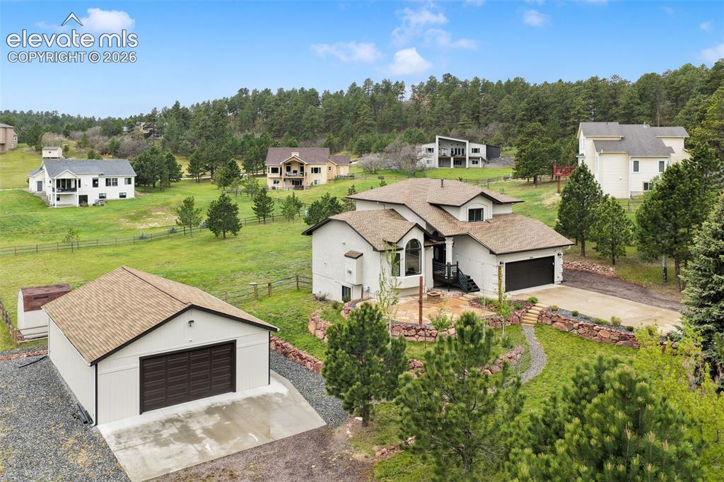Rarely does a property offer so much flexibility, privacy, and usable land in the desirable Monument location. Situated on 2 separately deeded lots sold together, this unique opportunity encompasses nearly 2 fully fenced acres in sought-after Lewis-Palmer District 38, just minutes from Mount Herman trails, Pike National Forest, shopping, dining, and easy access to Colorado Springs and Denver.A standout feature is the detached constructed heated oversized 4+ car workshop/garage, ideal for exceptional storage, workspace, and room for vehicles, trailers, and recreational equipment. The detached shop offers insulation, heating, cabinetry, and ample room for projects and hobbies. The property is fully fenced with electric gates operated by remote control or smartphone app. High-speed internet, natural gas, municipal water, RV parking, and outdoor space make this a rare acreage opportunity. Recent improvements include a brand-new roof, interior and exterior paint, updated landscaping, a flagstone patio ideal for entertaining and enjoying the outdoors, new carpeting, generator, and newer furnace and A/C.Inside, you'll find hardwood flooring, a gas fireplace, vaulted ceilings, granite countertops, and a functional layout designed for everyday living and entertaining. The upper level features a spacious primary suite with walk-in closet and adjoining bath, plus two additional bedrooms. The finished basement offers a large recreation room, fourth bedroom, full bath, and bonus space ideal for a home office, fitness room, guest suite, or hobby area. Enjoy the oversized deck overlooking the acreage with room for gardening, pets, recreation, and mountain views.Properties offering nearly 2 acres, a heated workshop/garage, RV parking, electric gates, high-speed internet, and proximity to trails, shopping, and city conveniences are exceptionally difficult to find. This is Colorado living with the space, functionality, privacy, and freedom many buyers have been searching for.