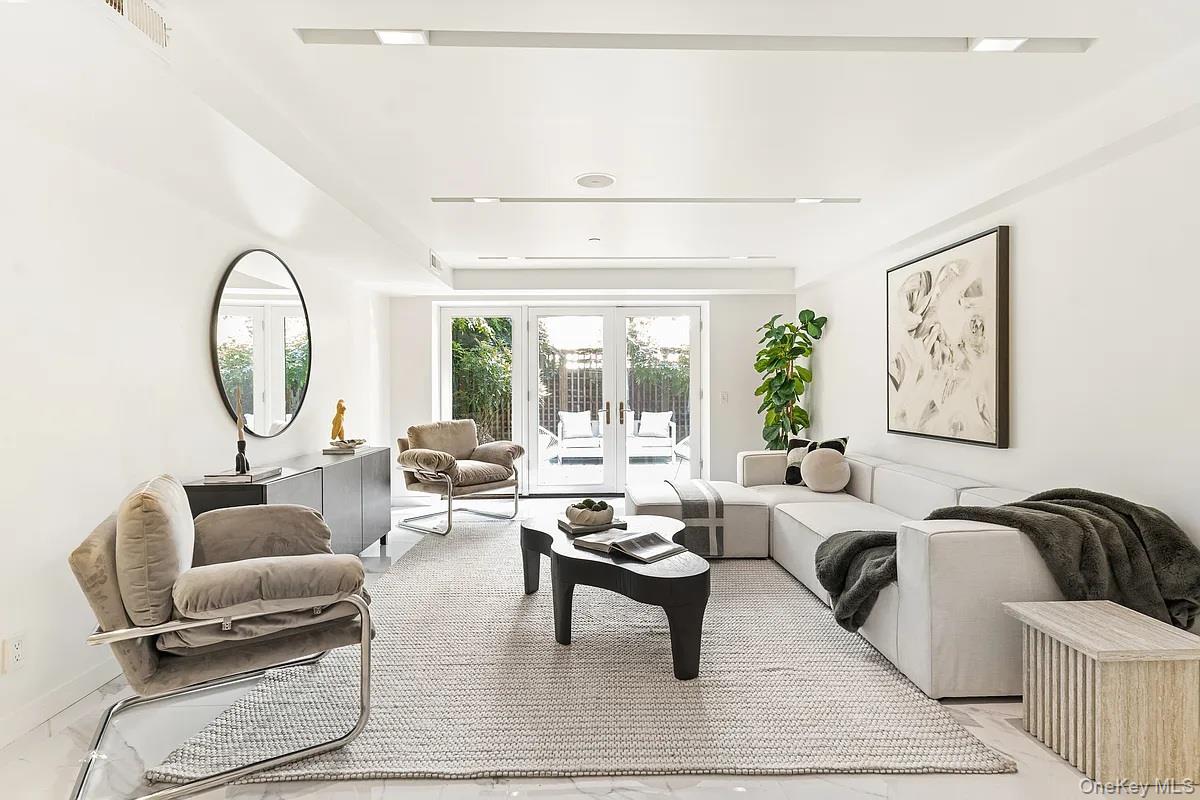 Upon entering this beautiful townhouse from the street level, you step into a spacious tiled foyer. This area leads to a large wood-paneled console that includes a roomy entry closet, a hidden staircase to the cellar, an elevator, and a powder room. Continuing through the house, you will discover a big informal entertaining area. This space features a full wet bar, a wine refrigerator, and French doors that open up to a lovely garden. As you ascend to the parlor floor, the impressive layout becomes clear, showcasing a magnificent main floor ideal for hosting guests and serving as the heart of the home. The south-facing living room boasts a custom floor-to-ceiling fireplace and a striking corner bay window that offers views of the surrounding architecture. The spacious dining room sits between the living room and a large, dream eat-in kitchen, which features custom white lacquer cabinets and all the modern conveniences you would expect. These include Dornbracht fixtures, a vented Wolf 6-Burner range with a griddle, Miele ovens with a warming drawer, a double-paneled Sub-Zero refrigerator and freezer, and a separate full-sized wine fridge. The third floor is dedicated to a large primary suite that occupies the entire level. This suite includes a south-facing bedroom with a wood-burning fireplace and a luxurious six-fixture primary bathroom. The bathroom features a separate water closet, a double shower, and an oversized deep soaking tub. Additionally, there are two walk-in closets and a bright corner den or private office located across from the bedroom. For added privacy, this entire floor can be closed off from the rest of the house at the top of the staircase. The fourth floor, located above the main suite, has two large bedrooms on each side of the house. Each bedroom includes a walk-in closet and its own bathroom. A bright bonus room in the middle is ideal for a playroom, den, or additional gathering space. On the fifth floor, there are two more bedrooms, both featuring spacious terraces. One terrace faces south, while the other has a large wraparound area to the north, offering stunning views of the Midtown skyline and the Chrysler Building. The northern bedroom boasts a lovely corner position with plenty of windows. Both bedrooms on this floor share a full bathroom with a window. The upper level includes another bedroom, which has a set of south-facing windows that overlook a view break. There's also an additional full bathroom with windows and a roomy laundry area that provides ample storage space. Located between Lexington and Third Avenues, this area offers great access to Midtown's business districts while keeping a pleasant neighborhood vibe on a residential street. It is also conveniently near major subway lines, including the 4, 5, 6, and the Times Square Shuttle at Grand Central Terminal