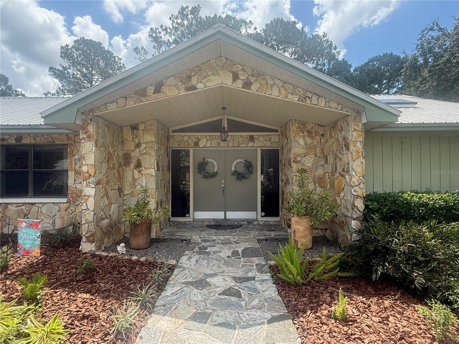 Rare FOUR-bedroom, corner lot home in the ever-desired Tarpon Woods neighborhood! Live surrounded by trees and nature while being close to everything (see a picture of the regular deer visits in photos). This 4/2.5/2 pool home on a huge, mature-tree lot has been meticulously maintained and updated by its 20+year owners. Newly redone landscaping beds lead to freshly painted front doors. The double door entry with decorative additional windows adds even more light to the well-lit foyer entrance and formal living room ahead. Throughout the house are high and volume ceilings, luxury vinyl plank (NO CARPET), storage closets at every turn, and updated systems (HVAC and duct work replaced in 2024, water heater 2024, new knockdown ceilings 2025, and more). Large, three-door sliding doors open to a beautiful, large screened porch and pool area with mature trees and the golf course beyond. To the right is the entrance to the primary suite, comfortably separated from the rest of the house as a retreat yet also overlooking nature outside. The large bedroom features a custom-designed closet big enough for all of HIS and HER items as well as an ensuite remodeled bathroom with a water closet, dual sinks, additional linen closet, and separate mirror and vanity area all illuminated by skylight. From the living room, access the 4th bedroom, complete with custom closets (currently used as an office). From the other side of the large dining room access the completely remodeled kitchen. You really have to see it to believe how much storage there is...dual walls of cabinets flank each side of this well-lit (thanks to a skylight) kitchen. The solid wood cabinets feature custom soft slide drawers as well as custom cabinets for the trash, etc. The stone counters extend into a bar big enough for six barstools to comfortably fit...an entertainer's delight! The kitchen is finished with a set in fridge, a hidden microwave in the cabinets, and two built-in ovens as well as an induction cooktop. A pass-through from the kitchen means food can flow freely from the kitchen to the patio for grilling, cookouts, and more. From the bar area, the family room opens as a huge space with massive windows plus 3 more sliding doors to the outside. The windows have powered window treatments and the fireplace has a circulation system for those few cold Florida nights...no need to turn the heat on! A hallway leads to two large secondary bedrooms, each with ceiling fans and custom-designed closets. The full bathroom between has been remodeled and includes solid wood cabinets and counters as well as a drop-down shower curtain. A well-designed shower/tub combo has a large shelf for candles, storage, etc. Another half bath, newly remodeled, is at the end of the hallway. The laundry room has yet more storage and a full sized washer and dryer set. The pool has been newly redone with fibertech (2024), a filter (2022), and motor (2024). The owners are not using the saltwater setup, but it is there if it should be desired to reconnect it. Between the included pool cleaner and the pine needle-proof screen enclosures, the pool stays sparkling all the time. The sellers also added a commercial-style metal entry bar for easy access up and down the pool stairs. The screened-in patio has room for a dining table plus a large seating area, and the flat overlay roof is newly redone (2023). Minutes to beaches, shopping, entertainment, and the airport, don't miss the chance to call this your new home!