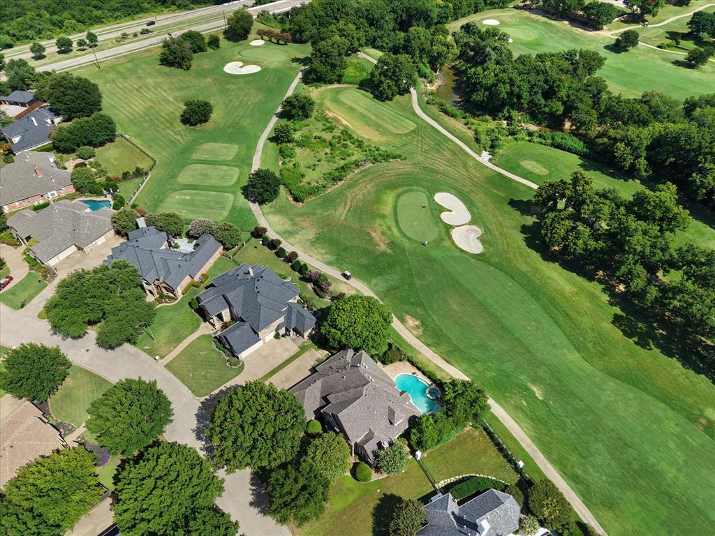 Nestled in a quiet cul-de-sac along hole 5 of the Walnut Creek Country Club golf course; this elegant 4-bedroom, 5-bathroom estate offers the perfect blend of privacy, comfort and refined design. From the meticulously manicured landscaping to the stately brick exterior, every detail reflects timeless curb appeal.
Step inside to find stunning 2¼” wide, ¾” thick red oak hardwood floors and a chef’s kitchen that’s truly a showstopper - featuring Taj Mahal quartzite countertops, a solid walnut island with farm sink w touch faucet, a gas cooktop with custom vent hood, double ovens and abundant custom cabinetry. The open-concept living area showcases a cozy fireplace, rich built-ins and walls of plantation-shuttered windows that overlook the resort-style backyard.
Unwind in the luxurious primary suite with a spa-inspired bath, freestanding soaking tub, dual vanities and expansive custom closet of your dreams. Upstairs you’ll find a second primary suite, a spacious game room complete with a wet bar, built-in cabinetry, a wine fridge and direct access to a covered balcony overlooking the golf course. A hidden flex space tucked inside one of the bedrooms offers the perfect spot for a home office, workout room, or creative retreat.
Enjoy outdoor living year-round under the spacious covered porch or lounging by the sparkling pool and spa. Additional highlights include a 3-car garage, upstairs balcony with peaceful golf course views and thoughtful upgrades throughout including a tankless water heater, 3 zoned HVAC units, roof repairs in 2025 and kitchen remodel in 2017. 
This impeccably maintained, move-in ready home in The Fairways of Walnut Creek presents a rare opportunity for luxury golf course living with convenient access to Mansfield ISD schools, major highways, premier dining, shopping and entertainment destinations.