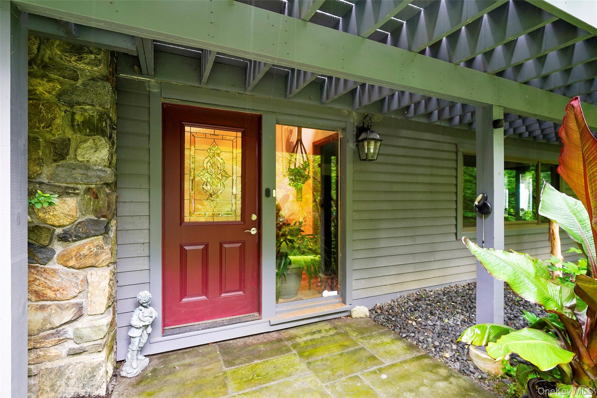 Privacy! Perfect Weekender! Endless Possibilities! Beautifully maintained and thoughtfully updated, this inviting home offers the perfect blend of comfort, convenience, accessibility, and exceptional indoor/outdoor living. Nestled in a private setting, it is an ideal full-time residence or weekend retreat. A welcoming entry with attractive wood-look tile flooring sets the stage, while hardwood floors flow throughout much of the home. The spacious formal living and dining areas feature a stunning fieldstone fireplace that creates a warm, inviting focal point, along with an elegant dining space perfect for entertaining or everyday living. The kitchen features wood-look tile flooring, white cabinetry, quartz countertops, a newer stove and microwave, a Pella casement window, washer/dryer hookup, and two doors providing access to the side yard and backyard deck. The spacious and bright primary bedroom offers sliders to the deck and a large primary bath with a walk-in shower, soaking tub, half-tiled walls, and two pedestal sinks. A second bedroom has access to the shared hall bath, which includes newer wallpaper, a new Pella casement window, tub, and vanity. A full main-level bath offers a walk-in tub and double-sink vanity. Additional features include new Renewal by Andersen windows, two washer/dryer hookups (one in the kitchen, one in the lower level), storage under the stairs, above-ground oil tank in the garage, central air conditioning serviced annually by Burke, a whole-house automatic generator, two rented propane tanks, new roof flashing, a cleaned flue, vent piping, and a two-car garage. Enjoy outdoor living with a new deck, stained in 2025; stairs to a stone-and-pebble patio; resealed flagstones; and a five-foot fenced-in area, ideal for a dog. Certain furniture may remain. Legal 2-bedroom, but 4-bedroom septic. 1250 gal septic tank. Taxes are without the Basic STAR exemption of $1447.22.
