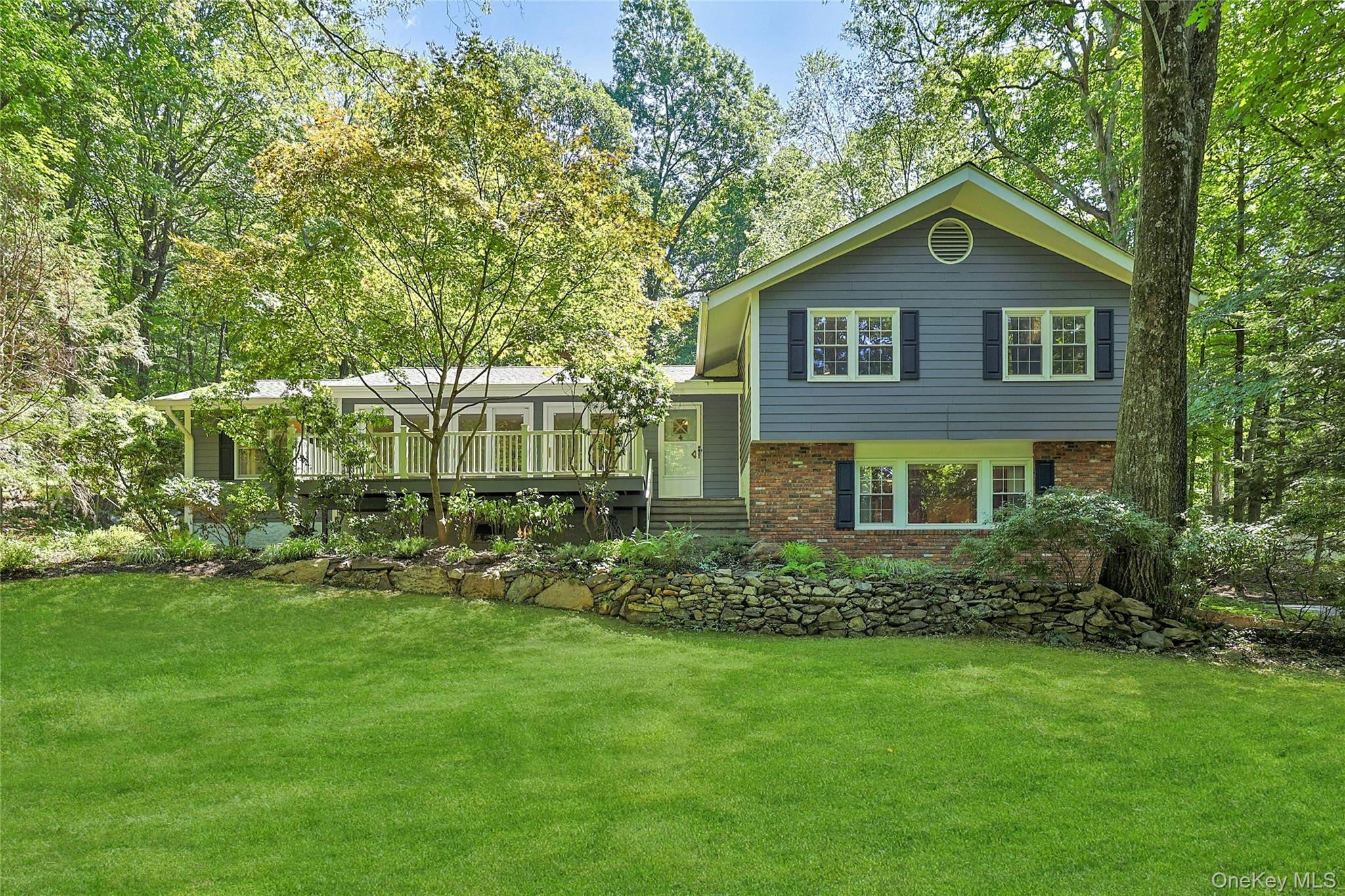 Striking frame and brick-front split-level. Welcoming front-deck. Grand and gracious living room richly adorned with a brick-front, wood-burning fireplace, built-in cabinetry, hardwood flooring, recessed lighting, and three front-facing, sliding glass doors to the deck, which illuminate the space in natural light, let gentle breezes cool the space, and provide easy access for indoor/outdoor living. Cater formal occasions in the front-corner, formal dining room, adjoining the living room and the eat-in kitchen, outfitted with stainless steel appliances, wood cabinetry, tile backsplash, and granite countertops. Grow and pick fresh herbs right from the box-type, greenhouse window over the kitchen sink. Dine casually in the open, airy, atrium-like breakfast room, with ceiling fan, large wall of windows, and slider to the new, generously proportioned bluestone patio for easy alfresco dining. The main-level home office is a flexible space for work, study or relaxation. Completing the main level, off the kitchen is a laundry/mud room with a door to the side yard. Upstairs reside three bedrooms and two full bathrooms, including a primary suite with walk-in closet and its own private bath ensuite, two spacious, front-facing bedrooms, both with outfitted closets and hardwood flooring beneath wall-to-wall carpeting, an updated hall bath with beadboard wainscoting, a natural stone-topped vanity and a shower over bathtub, and a large, cedar hall closet. Sitting downstairs is an inviting family room with large, front- and side-facing windows, a ceiling fan, recessed lighting, hardwood flooring and a side-entry door for easy indoor/outdoor access. Garage access is also on this level. The front deck and the new, rear, generously proportioned bluestone patio both provide enjoyable options for outdoor settings, including viewing the old growth trees and established landscaping surrounding the property, which is nicely accented with new bluestone pathways and outdoor landscape lighting. Plus, easy access to schools, and a central Chappaqua location.