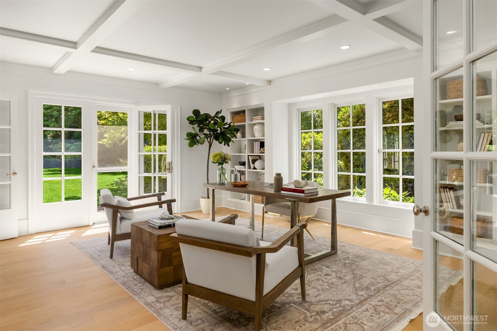 Sophisticated home office featuring a coffered ceiling and French doors leading to the yard.