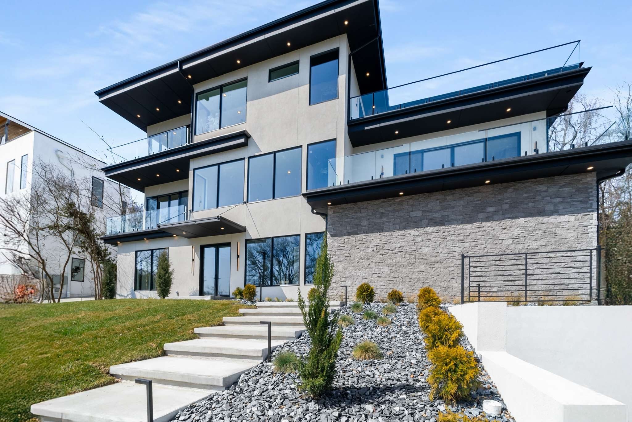 Exquisite MODERN MANSION designed by the award-winning Ryan Thewes, and tucked into the rolling hills of Belle Meade on 1.64 acres. This rare offering is located on one of the largest and most private lots in the area. Expansive living with over 8500 square feet including 5 bedrooms and 9 bathrooms (6 full baths, 3 half baths). Impressive two-story foyer with custom monotube staircase. One of a kind Quartzite entry wall with LED back-lighting feature and entry wall LED lighting. Glass-paneled elevator for with views of the Tennessee hills and the two-story foyer as you ride up that features commercial elevator motorized doors and two sides open to views.  Smart control lighting and whole-house audio. Conference-sized office just off the entry.  Palatial main floor living drenched in natural light and sweeping hillside views featuring a 72" linear fireplace with modern stucco surround. Primary suite with hillside views from the bedroom and soaking tub. Indoor-outdoor "pool house" wing of the house is a must see with pool bath, storage and pool laundry. Nashville Modern Cabinetry acrylic and custom wood cabinets, WOLF and SUB-ZERO appliances including modern cabinet -ront refrigerator, freezer and wine column. Walk-in pantry / skullery with a door out to the patio. Theater room / TV room with wet bar. INCREDIBLE 680 feet square feet of FINISHED FLEX space for a large home gym, full recording studio, golf simulator lounge or wine tasting suite with wine cellar - phenomenal opportunities for customization. Oversized three car garage with three 10' wide doors and additional space for motorcycles, toys and more. Recent appraisal $1.4M more than the asking price at just over $6.4M.