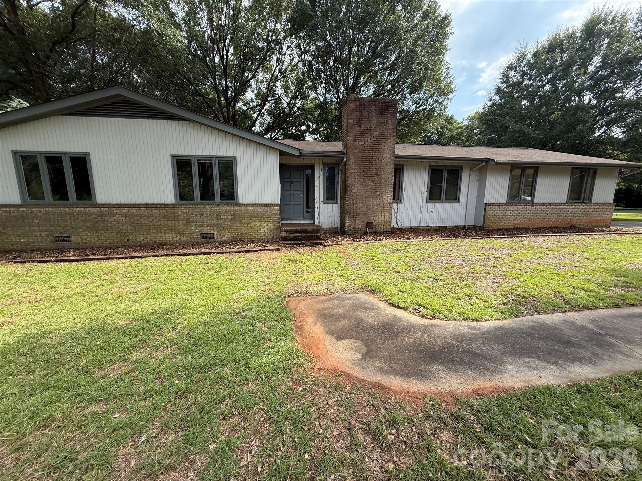 Opportunity knocks on a sprawling .79-acre corner lot shaded by mature trees! Built in 1975, this 3-bedroom, 2-bathroom home offers approximately 1,550 square feet and a fully fenced backyard — plenty of room to spread out, garden, or just enjoy the space. Just moments from Lake Wylie and Ebenezer Park, you'll have easy access to boating, fishing, walking trails, and waterfront recreation. A standout feature is the wired workshop with a covered work area, perfect for hobbyists, DIYers, or anyone needing extra storage and project space. The home needs updating throughout and is priced accordingly, making it a fantastic opportunity for buyers ready to build equity, add their own style, or take on a value-add renovation. With nearly three-quarters of an acre, mature landscaping, a workshop that adds real functional value, and Lake Wylie just around the corner, this is a rare find at this price point. Bring your vision and make it your own — convenient to Rock Hill shopping, dining, and major routes.