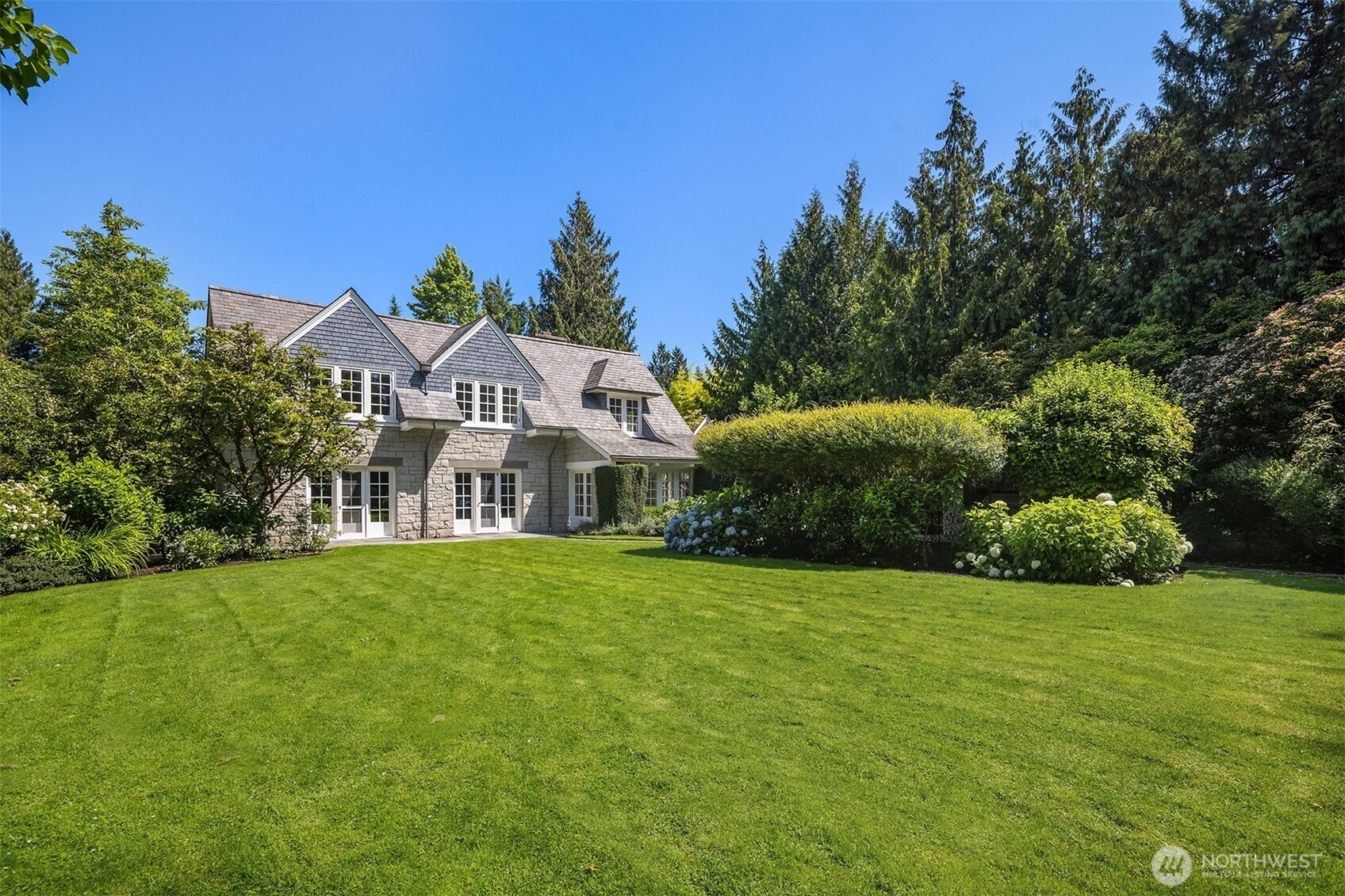 Elegant home framed by manicured grounds and mature landscaping.