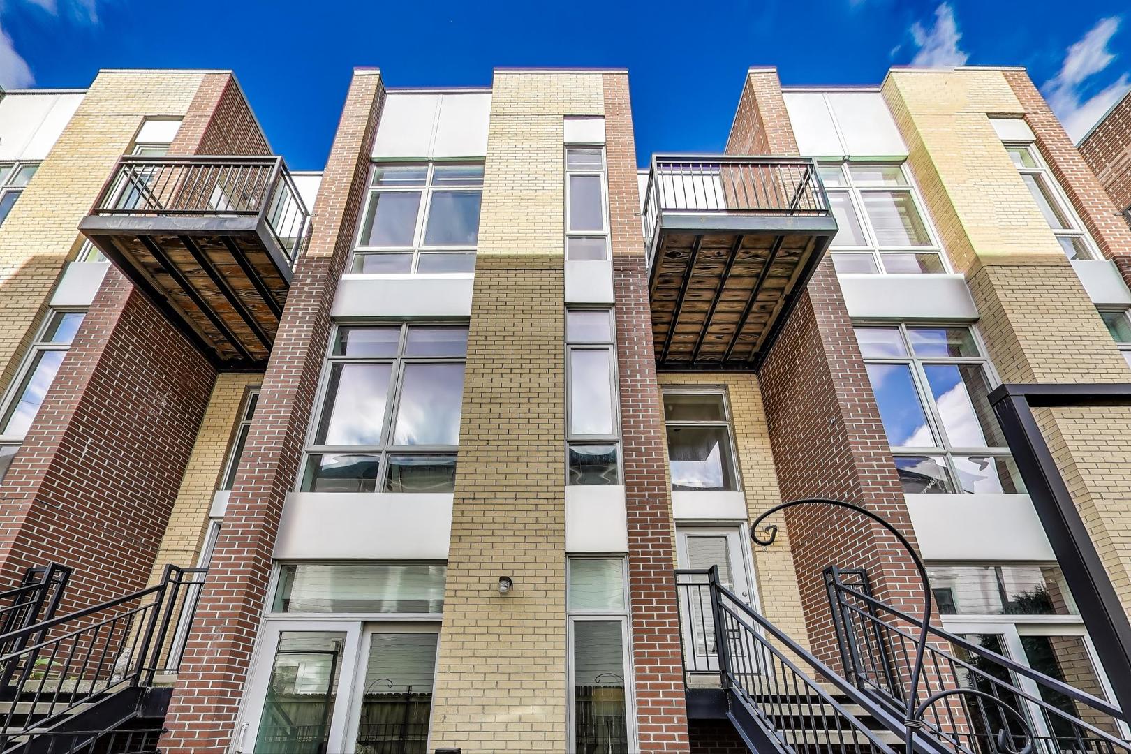 Beautifully cared-for, fee-simple, all-brick 4-bedroom, 3.1-bath townhome tucked away in a peaceful riverfront community surrounded by mature trees and lush greenery. Spanning nearly 2,500 sq. ft., this bright residence lives like a single-family home while offering the ease of a 2-car attached garage and three private outdoor spaces.  The main level showcases an inviting open layout with hardwood floors, a warm fireplace, and a chef's kitchen featuring quartz countertops, stainless steel appliances, a center island with seating, abundant cabinetry, and a stylish built-in buffet perfect for a coffee or wine bar. A designated dining area, living room, play area, powder room and balcony off dining room complete this floor.  Upstairs, you'll find three spacious bedrooms, two full bathrooms, and a washer and dryer. The primary suite is a true retreat with dramatic floor-to-ceiling windows, a walk-in closet, and its own balcony. The spa-like ensuite bath is complete with heated floors, dual vanities, a steam shower, and a soaking tub. The lower level adds flexibility with a 4th bedroom/office/gym, a full bathroom with direct access to a private patio. Ideally located where Lincoln Park meets Lakeview, this quiet community provides effortless access to Roscoe Village, Bucktown, Logan Square, Hamlin Park, Midtown Athletic Club, Fresh Thyme, Binny's, Hexe Coffee, expressways, and more. New photos coming soon!