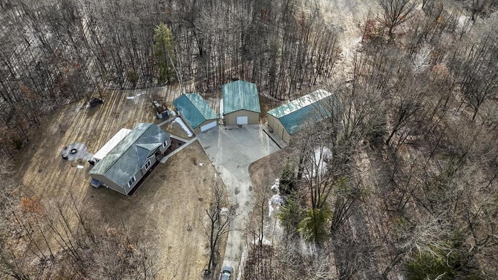 This 38.56?? acre property in Arenac County, Michigan offers an outstanding combination of comfortable country living, functional outbuildings and quality recreational land, all in a location that makes it ideal for a full-time residence, hobby farm, or Michigan hunting retreat.A 900?? foot concrete driveway welcomes you onto the property and leads back to the main home, creating a private setting tucked into the landscape. The residence offers approximately 3,480 total square feet of living space including the finished basement and has been designed with both comfort and practicality in mind.Inside the home you are greeted by a welcoming entry that opens into a spacious open-concept kitchen, dining and living area. The living room features an inviting fireplace with custom woodwork crafted from trees harvested directly from the property, adding a unique and personal touch to the space. The kitchen offers beautiful cabinetry, generous workspace and a layout that flows naturally for everyday living or entertaining guests. The home includes three bedrooms and two full bathrooms, with the primary bedroom located on its own side of the home for added privacy. The primary suite includes dual closets and a large walk-in shower. On the opposite side of the home are two additional bedrooms, a full bathroom, and a convenient laundry and mudroom area.The fully finished basement significantly expands the living space with a large entertainment area, built-in bar, workshop space, and plenty of storage. Just off the back of the home is a comfortable three-season room, which leads out to a stamped concrete walkway and fire pit area, providing a relaxing place to enjoy the property. The home also includes an indoor infrared sauna and outdoor hot tub, which will remain with the property, along with select furniture and an air compressor located in the workshop building.Outside, the property is exceptionally well set up for storage, hobbies, equipment, or potential small business use if permitted. A 26x40 insulated two-ca