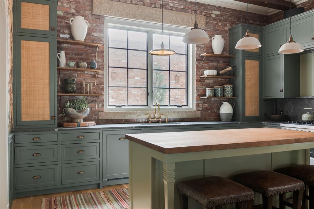 This is a truly one-of-a-kind Dutch-inspired home in the heart of Wheeler District, thoughtfully designed and built using the centuries-old practice of structural masonry. Constructed with sixteen-inch-thick walls and more than 90,000 bricks, this is a home defined by permanence, craftsmanship, and timeless architecture. Inside, the first floor is anchored by soaring eleven-foot exposed brick walls and a dramatic great room framed by a hand-crafted brick archway that immediately sets the tone. The kitchen blends traditional elegance with elevated functionality, featuring commercial-grade appliances, marble and quartz countertops, and generous workspace and storage. Upstairs, the primary suite and secondary bedrooms offer a quiet retreat, while modern efficiencies like aluminum-clad windows and geothermal heating and air provide comfort without compromising the home’s enduring character. Outside, a private ground-level brick courtyard creates the perfect setting for evenings al fresco and effortless entertaining. Every material, texture, and architectural detail was chosen with longevity in mind, creating a home that will only grow richer with time. 1900 Oso Avenue offers a sense of warmth, permanence, and craftsmanship that is nearly impossible to replicate.