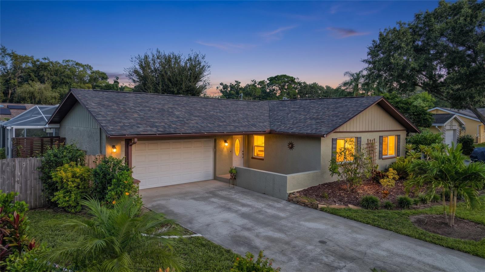 Dunedin – Discover this beautifully updated 3-bedroom, 2-bath pool home nestled in the sought-after community of Ravenwood Manor, where modern comforts meet the quintessential Florida lifestyle. Step onto the charming front patio and feel immediately at home, welcomed by tropical landscaping and inviting curb appeal. The spacious 2-car garage provides ample storage and convenience for daily living. Step inside to find a thoughtfully renovated interior with a bright, open-concept layout. The kitchen is a true showpiece, featuring elegant sage green cabinetry, gleaming quartz countertops, a stylish custom backsplash, a breakfast bar for casual dining, and a versatile center island. Perfect for both everyday meals and entertaining, the kitchen seamlessly connects to the living and dining areas, creating an effortless flow throughout the main living space. Durable tile flooring graces the kitchen and dining room, while warm laminate flooring adds comfort and sophistication to the remaining living areas. The expansive primary suite is a private sanctuary, boasting dual closets and a private en suite bath with a walk-in shower and transom windows that bathe the space in natural light. Two additional generously sized bedrooms offer flexibility for family, guests, or a home office, and share an updated hall bath with a tub/shower combo, custom tile surround, a large vanity, modern fixtures, and additional transom windows for natural light. The dedicated interior laundry room stands out with decorative tile flooring, custom shelving, and a contemporary barn-style door, making daily chores a delight. Glass sliding doors from the dining room open to a screened pool and outdoor living area, perfect for relaxing or entertaining in total privacy. The fenced backyard is a tranquil retreat, surrounded by tropical landscaping, and features a private outdoor rinsing station - ideal after a refreshing swim or an active day outdoors. Nature lovers will appreciate the home’s location adjacent to Jerry Branch, a meandering stream that connects Curlew Creek to Jerry Lake, providing a serene natural backdrop and opportunities to observe local wildlife. This exceptional property is ideally situated just minutes from vibrant Downtown Dunedin. Savor the local lifestyle with easy access to award-winning restaurants, bustling craft breweries, boutique shops, scenic waterfront parks, community festivals, and the picturesque Pinellas Trail. Weekends can be spent exploring the pristine shores of Honeymoon Island and Caladesi Island State Parks, hitting the links at nearby golf courses, or taking advantage of local marinas and abundant recreational opportunities. With convenient access to major roadways, premier shopping, healthcare facilities, and top-rated schools, this residence delivers the perfect blend of comfort, style, and coveted Dunedin living. Whether you’re searching for a primary residence, a seasonal getaway, or an investment opportunity, this home is a rare find in one of Pinellas County’s most desirable neighborhoods. With a New Roof 2024, New Windows 2024, and New Water Heater 2022, this home is move-in ready and waiting for its next owner. Schedule your private showing today to experience the very best of Florida living!