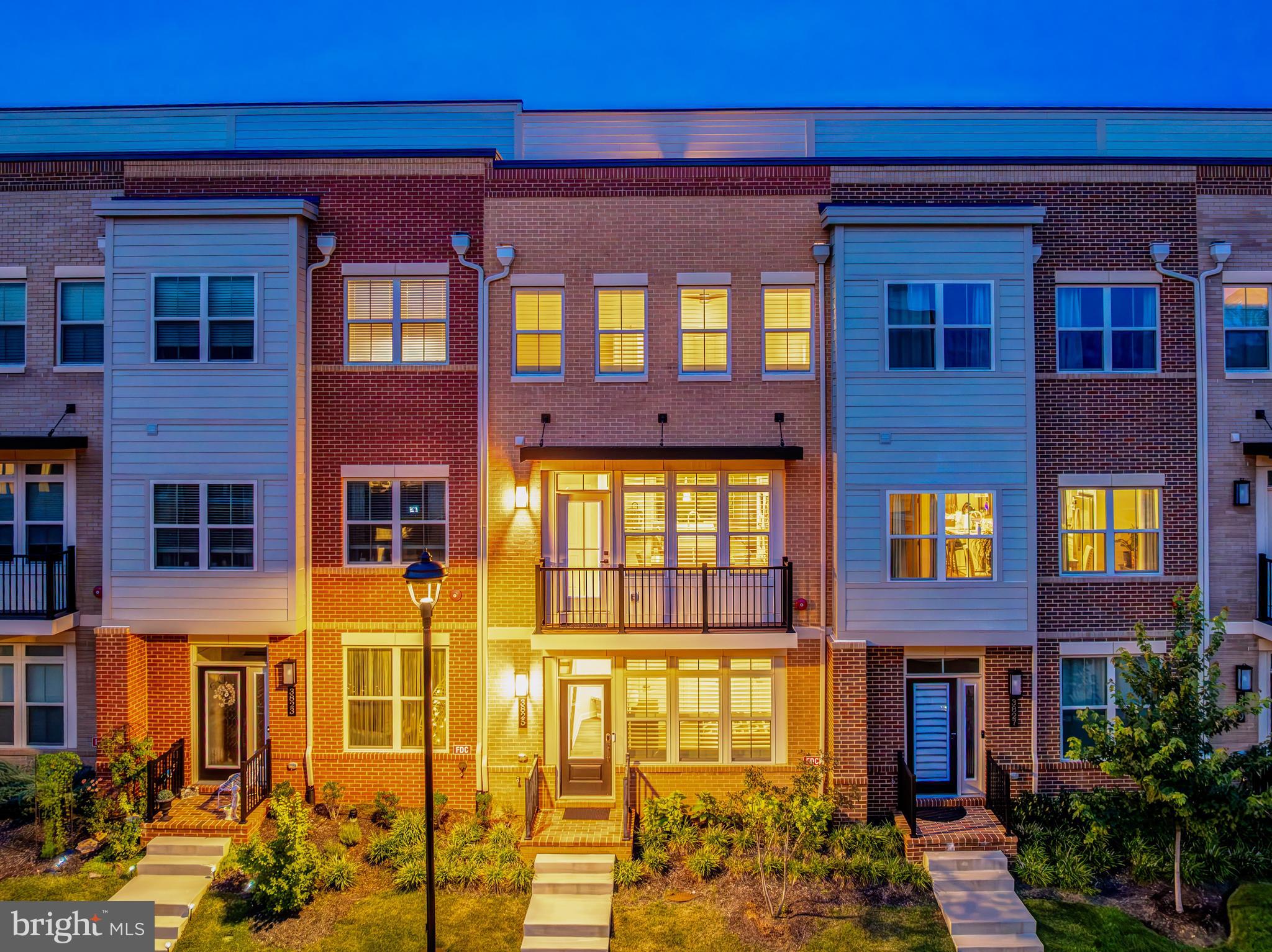Living in Boulevard IV Towns has spoiled me for anything less walkable. This four level modern townhome sits inside Fairfax City's most connected mixed use community, close enough to three neighborhood playgrounds and the baseball field at Pat Rodio Park to make weekends easy, and close enough to ChoSun Hwaro, Ned's New England Deck, Panera, and 99 Ranch Market that dinner decisions became the hardest part of my week. George Mason University is about two miles away, and the Vienna Metro station, the actual western terminus of the Orange Line, is roughly ten minutes by car, so downtown DC and Tysons are both genuinely reachable without living your life on 66. The HOA handles trash, snow removal, and common area upkeep, which means your weekends stay yours. Every floor is wide plank LVP, not one inch of carpet anywhere, and the stairs are solid oak the whole way up. The main level kitchen is where everyone ends up gathering, a wide island that seats four comfortably with pendant lighting overhead, 42 inch white shaker cabinetry, quartz counters, a gas cooktop, range hood, built in oven and microwave, and a fridge that all match. I added a butler's pantry station off the dining area along with a small office nook, because everyone needs somewhere to drop mail and answer one more email before dinner. The kitchen opens straight into the family room, which sits right next to the covered terrace, so hosting never feels like managing two separate parties, and the balcony off the dining area is where the grill lives. One level up, two primary suites each come with their own bathroom and walk in closet, real square footage, not an afterthought. The main primary has a fully tiled seamless glass shower and a dual sink vanity. The actual laundry room, with front load machines, is on this floor too, right where your laundry basket wants it to be. Climb to the top and you get a loft that opens onto the rooftop terrace, sky views included, which has become my spot for morning coffee, evening wine, watching fireworks on the Fourth, or just working from somewhere that does not feel like an office. There is also a full bedroom and bath on that level, and depending on what your life looks like it works as a guest room, a home gym, a media room, a studio, or a hangout space that stays comfortably separate from the main living area. On the entry level, a bedroom with a full bath gives you a place for overnight guests, aging parents, or anyone who would rather skip the stairs. Parking is covered both ways, a two car rear entry garage plus a full driveway that fits two more. The facade has real presence on the street, tall ceilings and abundant natural light carry through the whole house, and details like the tankless water heater, EV charger, custom window coverings, upgraded tile and quartz in every bathroom, recessed lighting on the main level, and wifi boosters on each floor were all chosen because I wanted this house to run well, not just look good. This is a home I built my life around, and I think you will feel that the moment you walk through the door.