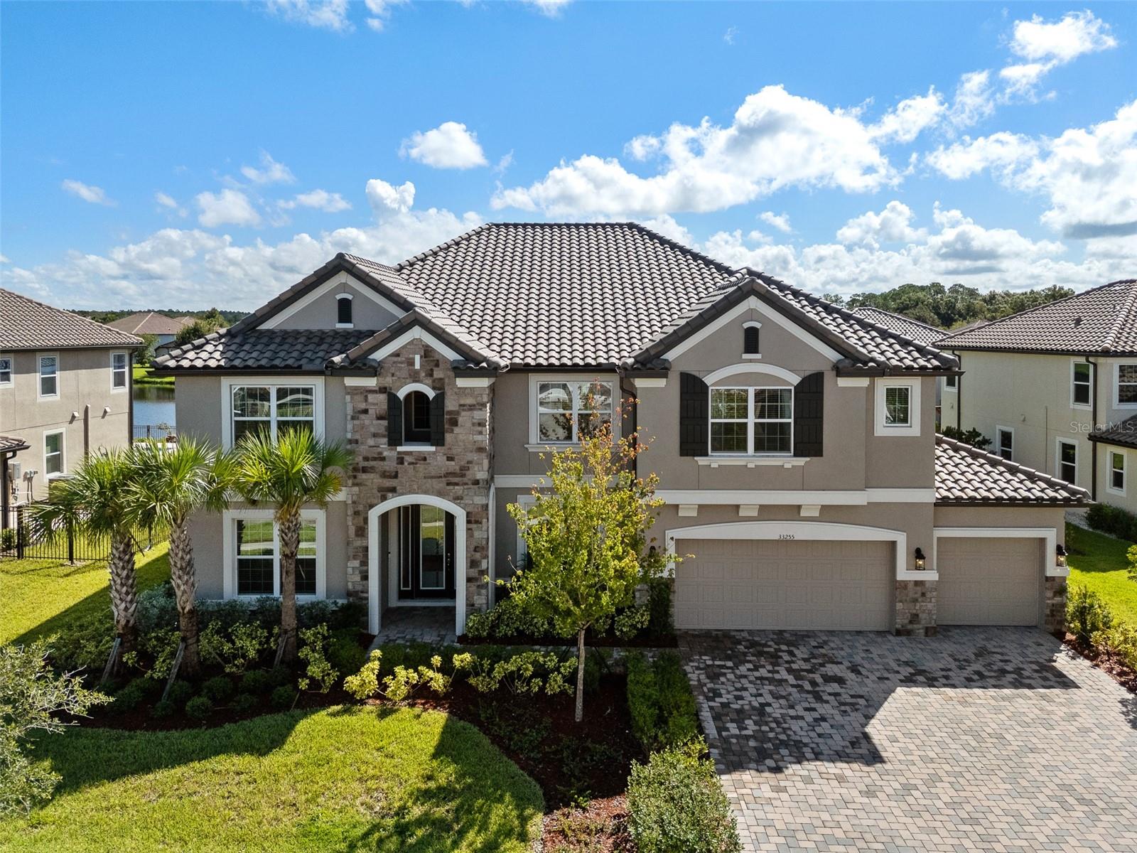 One or more photo(s) has been virtually staged. Welcome to 33255 Kateland Dr, Wesley Chapel, FL — a stunning 7-bedroom, 6-bathroom luxury home offering over 5,400 sq ft of exceptional living space. Nestled on a premium pond lot in the sought after Graybrook community of Watergrass, this meticulously designed residence combines modern elegance with ultimate comfort, creating an ideal sanctuary for everyday living and entertaining. Step inside to discover a spacious open floor plan featuring exquisite upgrades throughout. The chef’s kitchen boasts quartz countertops, upgraded cabinetry, a custom pot filler, and an oversized island, perfect for preparing meals and hosting gatherings. The kitchen seamlessly flows into the grand living area, creating a perfect space for both intimate moments and lively entertaining. The primary suite is a true retreat, showcasing tray ceilings, a luxurious freestanding soaking tub, and a separate glass-enclosed shower — offering a spa-like experience at home. Every bathroom features stunning quartz surfaces, adding to the home’s elegant design. The home also features tray ceilings in the master bedroom, dining room, and upstairs living room, enhancing the elegance and grandeur of these spaces. This home’s thoughtful features continue with additional recessed lighting throughout the interior and garage, a modern wired staircase, and a dedicated outlet in the garage suitable for electric vehicle charging. The outdoor spaces are equally impressive, with a screened-in lanai and balcony, a pool door with an outdoor shower head, and a dedicated outlet for a future outdoor kitchen. With a 4-car tandem garage, there is ample space for vehicles, storage, or a workshop. This home is truly designed for those who appreciate both style and functionality. Conveniently located only 5 miles from I-75 and minutes from the Epperson Lagoon, Publix, Starbucks, top-rated schools, shopping, and dining.