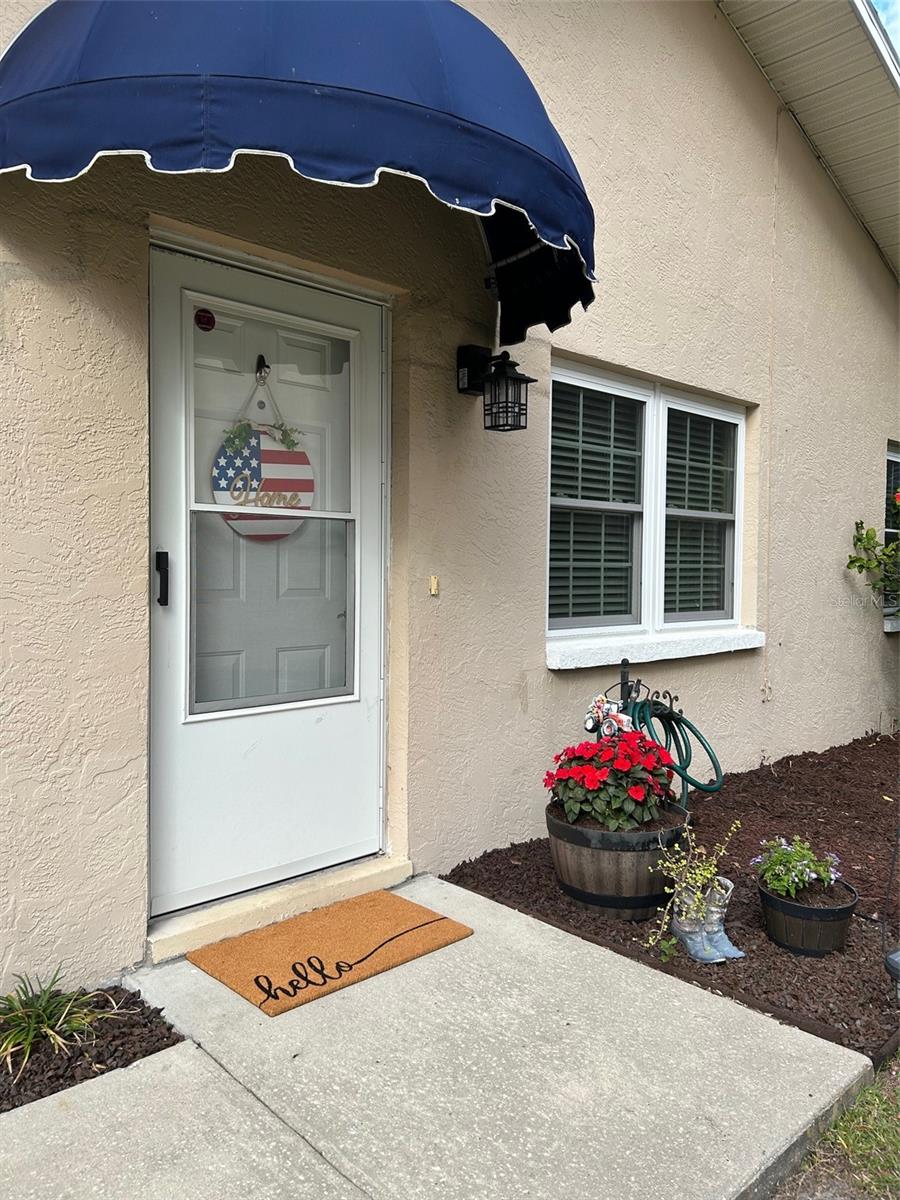 Updated light and bright 3 bedroom 2 full bath END UNIT  Villa is now available!  Village at Bonnie Bay is a popular community with only 9 residents and a low turnover. There is plenty of parking for yourself and guests, and its location at the end of 62nd offers some privacy and no thru traffic.   Once inside the tasteful décor and comfortable atmosphere makes you feel right at home!  You will notice the newer luxury Vinyl flooring and cathedral ceilings which makes the home look much larger and open concept.  The kitchen has a breakfast bar for quick meals, a newer microwave and stainless appliances.  There is a closet pantry for convenience and even room for a small table. There is also additional storage in the laundry room that's just off the kitchen.  Step outside to your backyard with lots of green space and a roomy deck/porch to enjoy our beautiful Florida weather! The Primary bedroom has a walk in closet with attic access and sliders to your back porch/deck, and a bathroom with a newly tiled shower. The other 2 bedrooms are a good size with a lot of light and closet space. Updates include hurricane windows, ceiling fans in all bedrooms, 2 ton heat pump (Jan 2025) serge protectors on main breaker, garbage disposal and the water heater is about 6 years old.  The association (HOA) is resident run, and include water/sewer/trash and lawn service.