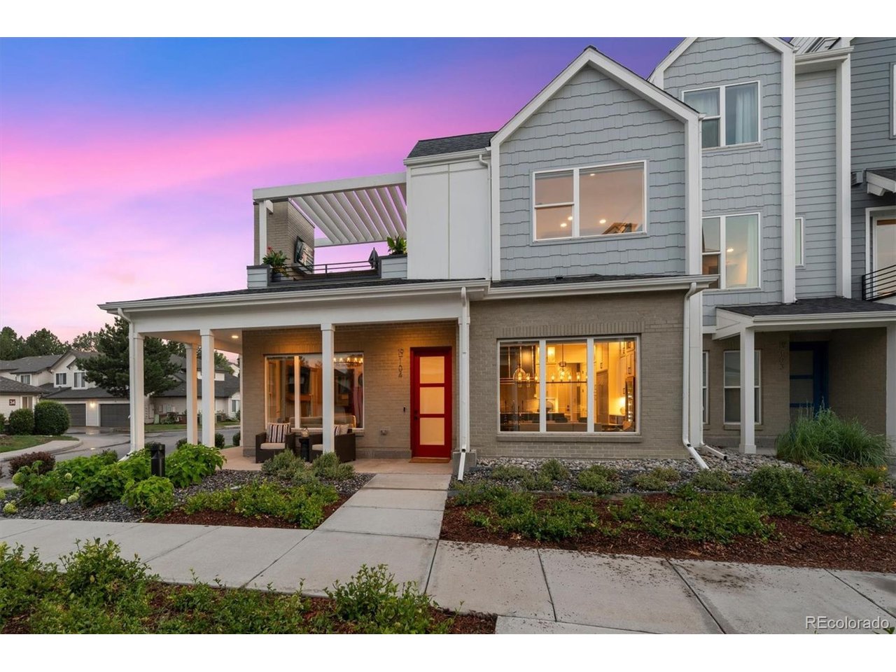Experience luxury living in this sun-filled corner-unit townhome in the gated Prelude at TAVA Waters community. Ideally situated on a premium corner lot with southern exposure, this beautifully upgraded residence offers over $100,000 in designer enhancements and exceptional indoor-outdoor living. The open-concept great room is filled with natural light from expansive windows and features motorized smart shades, Restoration Hardware lighting, and a gas fireplace. The chef's kitchen is equipped with a Wolf six-burner gas range, custom hood, Sub-Zero refrigerator, Bosch dishwasher, Viking microwave, dramatic designer backsplash, beverage refrigerator, six-foot temperature-controlled wine cabinet, oversized island, and upgraded custom cabinetry with pull-out organizers and elegant cabinet lighting. Thoughtfully designed for both everyday living and entertainment, the kitchen offers exceptional functionality and style.The main-floor primary suite provides a spacious retreat with an oversized walk-in closet, additional storage closet, and a luxurious en-suite bath featuring dual vanities and an oversized shower with built-in bench. Upstairs, a versatile loft with wet bar opens to a spectacular outdoor terrace featuring a fireplace and TV hookups, creating the perfect setting for entertaining or relaxing. Custom upper-family-room cabinetry with integrated accent lighting adds both sophistication and storage to the space. A second primary-style suite with walk-in closet and private bath offers ideal accommodation for guests or multigenerational living. Additional highlights include a custom mudroom, enhanced laundry space, powder baths on both levels, and an attached two-car garage.