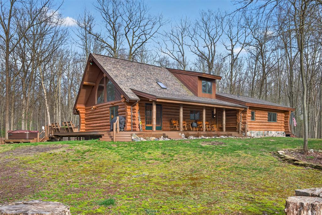 If you have been waiting for a log home that offers both character and usable acreage without sacrificing convenience, this 16.13+/- acre Midland Countyproperty deserves your attention. As you enter the long paved driveway, you are guided through mature trees that create a sense of privacy and anticipation as the home comes into view. The setting immediately establishes the feeling of space and seclusion while still being within close proximity to Midland and Mt. Pleasant. The full wraparound porch completes the first impression, offering a welcoming place to relax and enjoy the peaceful surroundings.Inside, the craftsmanship of the home is immediately apparent. Natural log construction, exposed beams and abundant windows work together to create a warm, inviting environment filled with natural light. The open living and dining area provides both space and functionality, allowing the home to feel comfortable for everyday living while also accommodating gatherings with ease. Just beyond, the kitchen offers generous counter space, ample cabinetry and a layout that keeps everything within reach while maintaining connection to the main living areas. The main level primary suite offers a comfortable retreat, featuring dual sinks, a walk-in shower and a spacious walk-in closet. Continuing down the hall, two additional bedrooms are well-sized and conveniently located near a full bathroom highlighted by a classic clawfoot tub that complements the timeless character of the home. At the end of the hallway, a quiet seating or library area creates an inviting space to relax or unwind. Above the main living area, the loft overlooks the open space below and provides flexibility for additional living area, workspace, or entertaining, while maintaining connection to the home's open feel. Moving to the lower level, the finished space continues to add versatility with an additional bedroom and connecting bonus room that can serve a variety of uses depending on your needs. The lower level also includes laundry, utility space, and