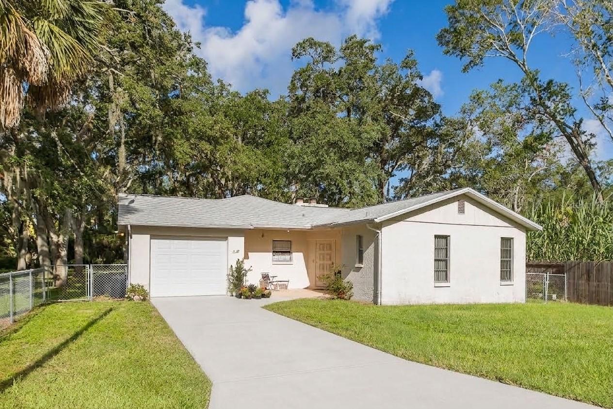 RARE FIND IN NEW PORT RICHEY! OVER 1/2 ACRE LOT WITH UPDATES & UNIQUE CHARACTER!Discover incredible potential and unmatched land size in the heart of New Port Richey! Situated on a massive 0.56-acres , which includes 3 additional parcels: Lots 57, 58, & 59 in addition to the .14 parcel (lot 60) that the home is situated on.  This fully chain-link fenced 2-bedroom, 2-bathroom home offers rare space and versatility that is nearly impossible to find in this area. Bring your boat, kayaks, and beach gear, as this home is nestled just minutes from pristine Gulf Coast beaches, public boat ramps, and scenic waterwaysInside, you'll find a massive family room with dedicated heating and AC, ideal for entertaining or relaxing. The cozy living space centers around the adjacent brick fireplace featuring a built-in pizza oven—a truly unique feature for home chefs and gathering friends.Major capital expenses have already been addressed! Enjoy peace of mind with a newer roof (2021), HVAC (2021), updated electrical (2025), new garage door (2025), new LVP flooring (2025), plus smart features including electronic front/back door locks and a smart thermostat. A brand-new refrigerator, washer, and dryer (2025) are also included!Note: The home was affected by Hurricane Helene and has been remediated. It is now ready for your personal cosmetic updates and finishing touches. With major big-ticket items already updated, a little bit of TLC will turn this unique property into a dream forever home or an outstanding investment opportunity.