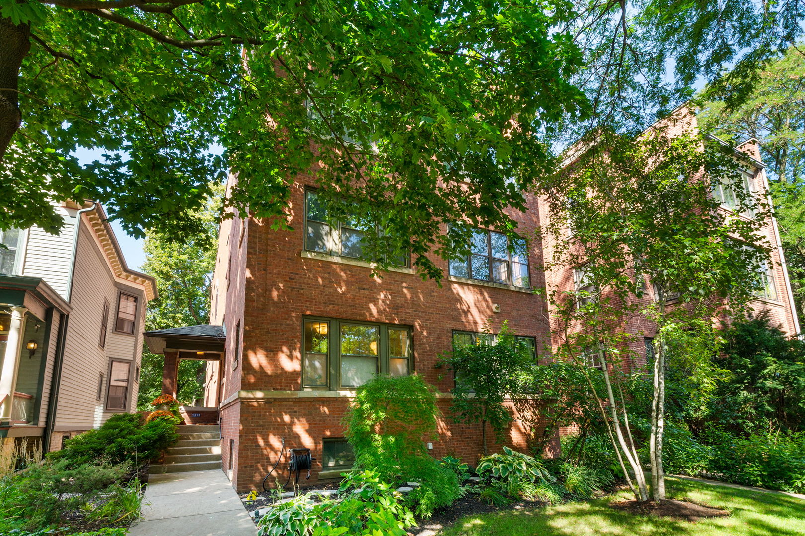 RARELY available high 1st floor sunny east facing MOVE IN READY 3bed/2bath vintage home tucked away just a few blocks from downtown Evanston! This renovated 28' extra-wide jumbo red brick three flat offers a truly elegant and spacious floor plan that feels more like a home than a condo! The space has been tastefully renovated with an artist's attention to detail and luxury rarely found at this price point! You will love the mix of modern style and classic vintage charm...so many smart upgrades have already been done for you! A beautiful covered front entry with original quarter sawn oak front door opens to a large foyer overlooking the light living room with a wood burning fireplace and lots of windows. Large separate dining room opens to a pretty sunroom with new marble tile floor for all your plants. A true cook's kitchen has granite counters, stainless steel appliances and an original built-in hutch + a custom organized pantry with side by side washer/dryer. Center hall layout with three bedrooms and two baths all on one level. Wheelchair accessible full hall bath with bright white subway tile ROLL IN shower with custom glass enclosure. Primary bedroom has two closets, a gut rehabbed en-suite bath with soaker tub, subway tile shower and Toto toilet with washlet. Second bedroom makes a great guest suite and third bedroom is the perfect den or home office with tandem flex space. Private deck and common backyard slate patio with gas grill. Central AC, a HUGE basement storage space (13x13 with built-in shelves) plus a communal recreation area featuring a pool table, refrigerator and extra freezer,  and one assigned parking space in back included. Gorgeous tree-lined street surrounded by historic homes. Walk to downtown Evanston's cafes, dining, Trader Joe's, Purple line, Metra or ride your bike to the Lake and beach.  Gardeners have lots of opportunities here!