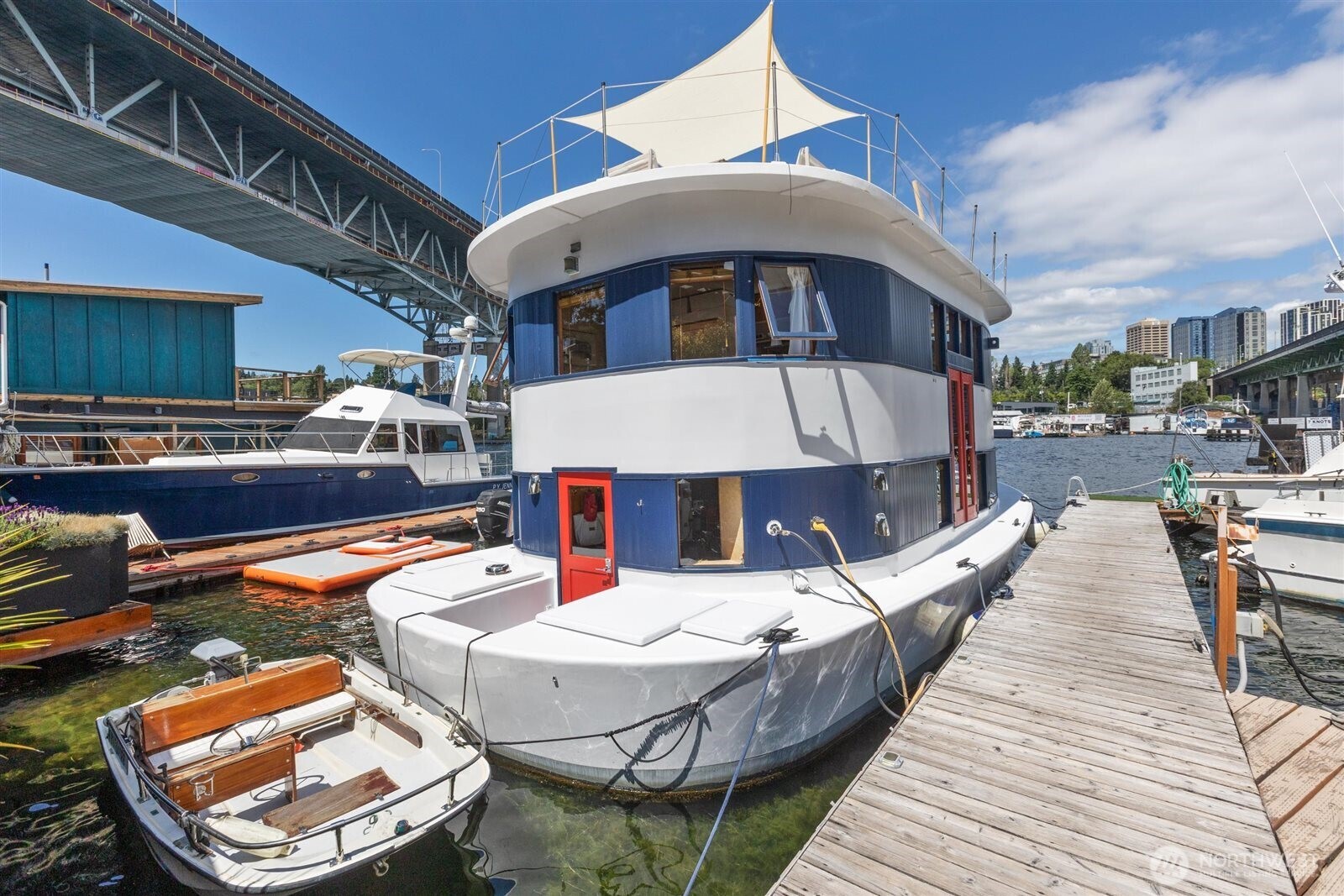 Welcome to Andante, a spacious 2BR/2BA plus den houseboat w/ loads of recent upgrades, conveniently located in the Eastlake/Portage Bay neighborhood(s) just across the bridge from the University of WA.  Enter through bright French doors to your completely renovated kitchen w/ new cabinets, Corian counters, high-end appliances, pantry, rafter wine rack & thoughtful filtered-water station--bar seating, open concept & built-in dining make this a great entertainment space that flows into your wood-wrapped living area w/ a gorgeous beam ceiling & curved windows to enjoy your direct Lake view. Ensuite laundry & full bath on main level. Upstairs you'll find a perfect home office space, 2nd bedroom w/ Murphy bed to maximize utility/flexibility & luxurious main bedroom w/ ensuite bath and wrap-around views that make you feel like you're relaxing on vacation every day.  Interior stairs to your large completely new roof deck make a great private oasis or entertainment space to share this magical experience with friends! Space for your accessory boat for you to enjoy the Lake or tie up at one of the many nearby restaurants. Lots of transit nearby including Lightrail station! City-registered FOWR 877.