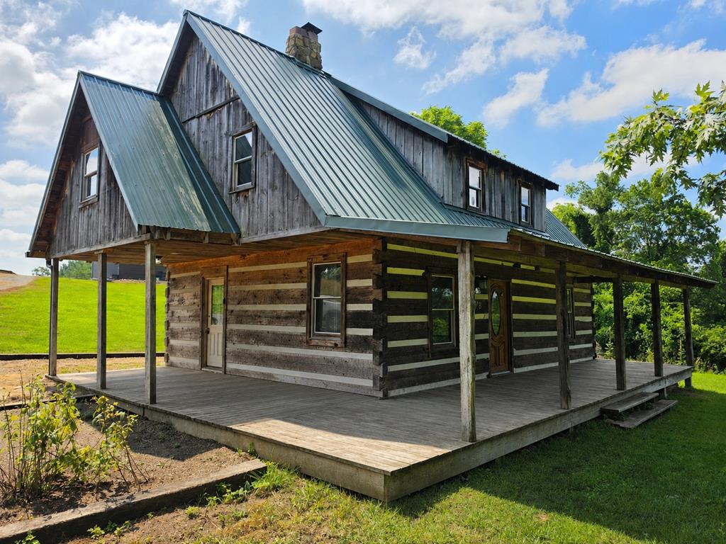 Situated on 7+/- acres ready for livestock, this rustic log home offers a rare combination of country charm, privacy, and modern updates. The home features three bedrooms, one and a half baths, updated electrical wiring and plumbing, and a stone fireplace with gas logs in the living area. Equestrian enthusiasts will appreciate the graded riding arena and automatic watering trough, while the 30' x 30' x 13' hay barn and additional outbuilding provide ample space for animals, equipment, storage, or workshop projects. Tucked away in a peaceful setting with captivating views, this property offers the seclusion of rural living while remaining just minutes from the New River Trail, New River, Jefferson National Forest, horseback riding trails, and Iron Mountain Horse Camp. This unique property is a must-see for anyone seeking the warmth and character of a log home along with the practical amenities needed for livestock, horses, and an active outdoor lifestyle. Call today!