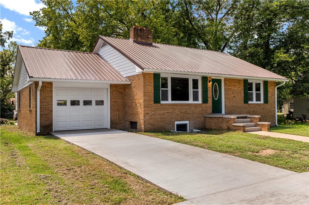 This 3 bedroom, 3 bath home pairs the timeless curb appeal of a Mid-Century brick ranch with the comfort of a full modern remodel.

Step inside to discover superior lighting and bright, airy finishes throughout. Refinished hardwood floors, fresh paint, modern fixtures, and a cozy fireplace set the tone in the main living room. The eat-in kitchen and dining area flow together beautifully with updated cabinetry and stylish tile work.

The main level offers two bedrooms and two brand-new bathrooms with custom tile showers and sleek vanities. The lower level features a true third bedroom retreat with its own full bath and expansive walk-in closet, along with an unfinished bonus room offering potential for a future fourth bedroom, home office, or second living area.
The remodel was completed in 2025, including major system updates: HVAC, water heater, electrical, and plumbing.

Outside, you’ll love the brand-new concrete driveway, a metal roof for lasting durability, and the convenience of a drive-through garage with two overhead doors.
Move-in ready, beautifully bright, and updated where it matters most, this Mid-Century brick ranch is ready for its next chapter.