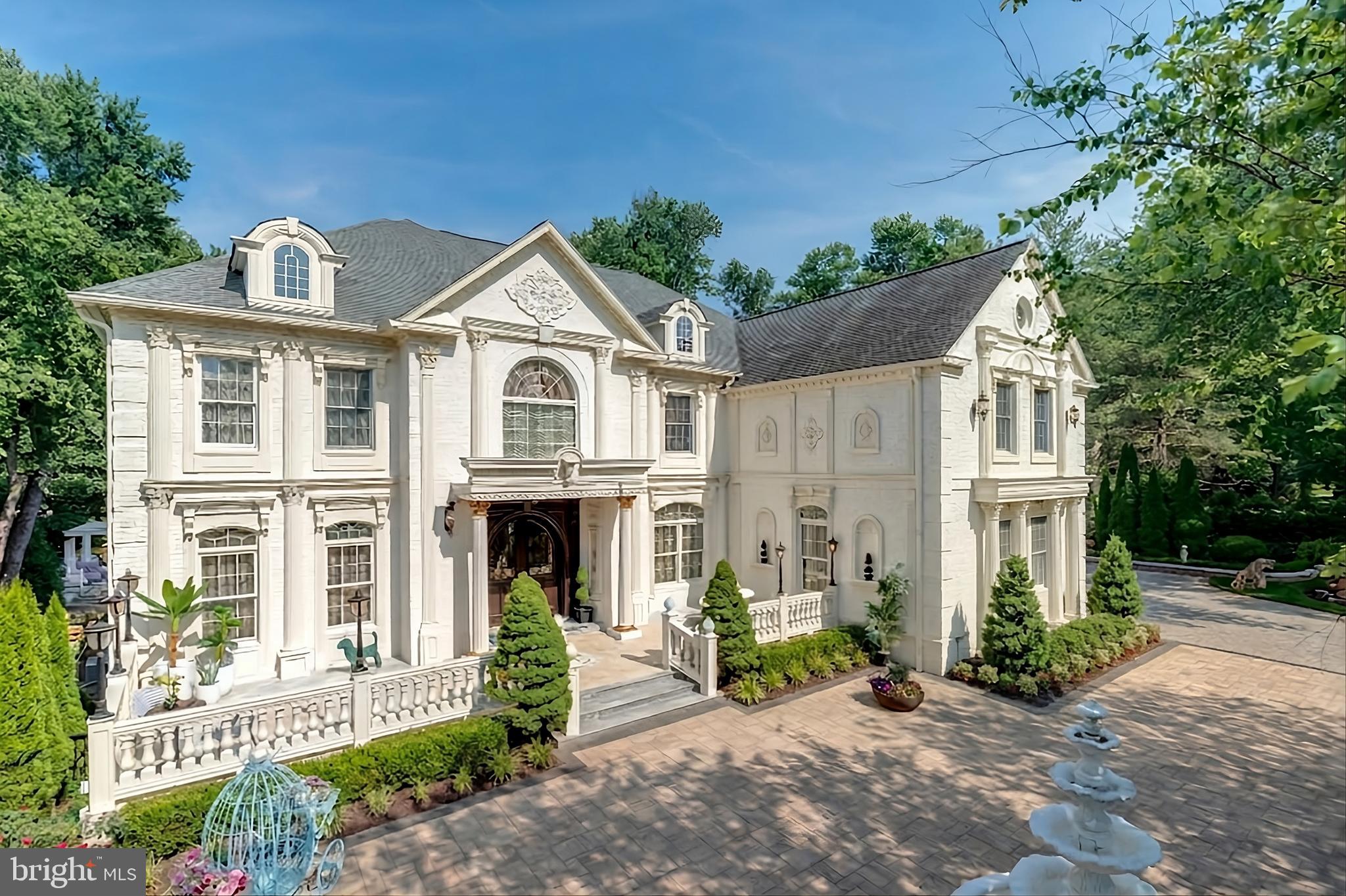 Exquisite artistry, quality craftsmanship, and a touch of glamour combine in this spectacularly appointed 11,000+ sq. ft. manor, set on .89 lush acres. Sited near the Potomac River and moments from the quaint shops and fine dining of Great Falls village, this impressive estate showcases luxurious living at every turn.A grand marble foyer sets the tone, with lighted recesses, gold-gilded trim, and sweeping views of the home’s richly designed interiors. The formal living and dining rooms feature antique mirrors, crystal chandeliers, intricate ceiling medallions, and decorative hardwood floors with inlaid wool carpeting.At the heart of the main level, a breathtaking reception area rises two stories, offering an ambiance of elegance and exceptional detail. The richly paneled library is clad in hardwood and features a fossil-stone granite wall with built-ins and fireplace. A coffered-ceiling drawing room includes 11 glass showcases—perfect for art or collectibles. Nearby, a bright music room with bamboo flooring and iron chandelier offers quiet refuge.The chef-caliber gourmet kitchen impresses with an 8x5 ft. “Louise Blue” granite island and premium appliances. A granite breakfast bar and informal dining area complete the kitchen. Adjacent, a vaulted solarium with bamboo ceiling and French doors opens to expansive decks and lawns, ideal for indoor-outdoor entertaining.Additional amenities on this level include a paneled elevator, pantry, butler’s pantry with copper sink, mud room, and direct access to the 4-car garage.Upstairs, the opulent owner’s suite is a private sanctuary that features a tray ceiling, Brazilian cherry flooring with a 100% wool inlay rug, and a cozy sitting area with silk carpet before a marble fireplace and media screen. A morning kitchen offers private refreshment.The walk-in gallery closet is a boutique experience, with Thomasville cabinetry, center Travertine island, cedar-lined wardrobes, and chandelier-lit tray ceiling. The spa-like primary bath stuns with a central soaking tub before an electric fireplace, dual vanities with 24k gold-gilded sinks, media-screen mirror, and a separate commode room with decorative vanity. Glass-enclosed steam and marble showers, stone seating, and mosaic tilework complete the indulgent space.Three additional bedroom suites each feature designer bathrooms and walk-in closets. A full laundry room with LG washer/dryer and whirlpool sink completes the upper level.The lower level embraces a sleek, club-like vibe. Descend via curved staircase with leopard-print carpet to a modern lounge featuring a golf simulator, lighted mosaic bar, billiards area, and expansive rec room—ideal for lively entertaining.A dramatic home theater, entered through a historic Hotel Washington door flanked by theater masks, includes a custom wool carpet medallion, three-tier leather seating, granite bar, and immersive surround sound.Also on this level: a 5th bedroom with spa bath, sauna and steam shower; a Tuscan-style wine cellar and tasting room with stone and granite walls; and a utility closet with stacked washer/dryer for guests or staff.Outdoor living is equally impressive. Walk out to a tiered granite terrace with a summer kitchen, built-in BBQ, and stone fireplace. A generous deck overlooks landscaped lawns and a newly built pool, plus a hot tub with recessed TV and radio—perfect for private relaxation or elegant entertaining.