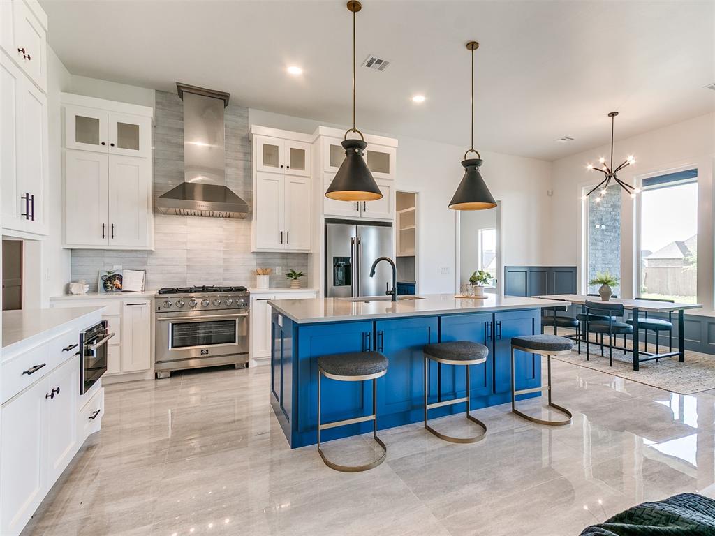 *SELLER CREDIT - $10K USE YOUR WAY!*Modern design meets exceptional functionality in this stunning custom home, where soaring ceilings, taller doors, and expansive picture windows fill the space with an abundance of natural light. Large-format tile flows throughout the main living areas, creating a clean, sophisticated aesthetic that perfectly complements the home's contemporary style. The chef-inspired kitchen is both beautiful and practical, featuring Forno appliances, a built-in microwave, walk-in pantry, oversized island with abundant storage, and a refrigerator that remains with the home. Just beyond the kitchen, a spacious second living room or bonus room with custom built-ins offers endless flexibility for entertaining, a media room, or play space. Designed with everyday living in mind, the oversized laundry room includes a utility sink, built-in drying rack, and exceptional storage. A mud bench welcomes you from the garage, while an additional flex room with its own garage access creates the perfect space for a home gym, art studio, hobby room, workshop, or additional storage. The thoughtfully designed split floor plan provides privacy, with a luxurious primary suite showcasing beautiful trim details, wood beam ceilings, and private access to the backyard. A convenient half bath serves guests, while every detail throughout the home reflects quality craftsmanship and intentional design. Step outside to enjoy the expansive covered patio, perfectly positioned with a north/south orientation for comfortable shade throughout the day. Thoughtful exterior up-lighting and down-lighting enhance the home's striking curb appeal after sunset. From its elevated finishes to its versatile layout, this home truly offers a level of design and functionality that is rarely found. Property is also shop approved!