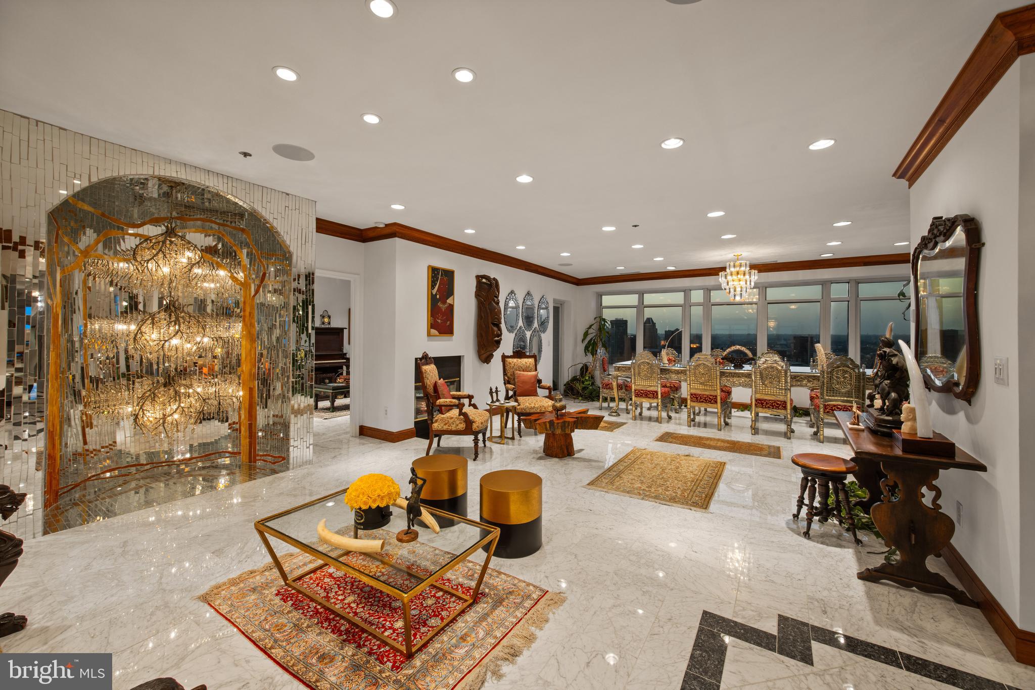 Offered for the first time in more than two decades, this residence is widely regarded as one of the most coveted penthouses on the East Coast, a truly once-in-a-generation opportunity available exclusively by private appointment. Occupying the entire 26th floor of Harborview Towers, this extraordinary residence encompasses more than 7,000 square feet. Located just beneath the Towers’ famed illuminated beacon, it combines two penthouses into one magnificent home, delivering unparalleled privacy, exceptional scale, and breathtaking “Top of the World” living. A private keyed elevator opens directly into an exclusive elevator lobby, setting the tone for an arrival unlike any other. Designed for both grand entertaining and everyday luxury, the residence showcases Italian Carrara marble flooring throughout, exquisite oak crown molding, sparkling floor-to-ceiling mirrored accents, dimmable recessed lighting, and magnificent crystal chandeliers, creating a timeless sense of elegance inspired by Le Château de Versailles and its famed La Galerie des Glaces. A dramatic grand hallway connects the east and west wings, leading to a spectacular floor-to-ceiling mirrored crystal chandelier, a stunning architectural focal point of the residence. The thoughtfully designed floor plan features two expansive primary suites, three additional bedrooms, four full bathrooms, including two ensuite primary baths, and two additional powder rooms. Multiple living spaces include two grand great rooms, a spacious family room, formal dining room, mirrored sunroom and garden, and music and vinyl room, as well as both a main kitchen and a separate chef’s kitchen. Two fireplaces and a custom oak and granite bar complete the home’s remarkable entertaining spaces. Outdoor living is equally impressive. A stunning 500 square foot open-air waterfront terrace offers sweeping, unobstructed views to the horizon, complemented by six additional balconies for a total of seven private outdoor living spaces. From every room, enjoy spectacular panoramic views spanning the Baltimore skyline and Central Maryland, with clear sightlines extending to Northern Baltimore County, the Eastern Shore, Howard County, Southern Maryland, and beyond. The residence provides a front-row seat to Baltimore’s iconic Fourth of July and New Year’s Eve fireworks, air shows, boat shows, and vibrant waterfront events. Additional features include an integrated Sonos sound system, a private ADT security system, four underground parking spaces, and multiple dedicated storage units. The residence is available for purchase unfurnished or, for an additional premium, with select antique and designer furnishings. This is more than a penthouse. It is one of the most extraordinary private residences on the East Coast, a legacy property that is truly one of one.