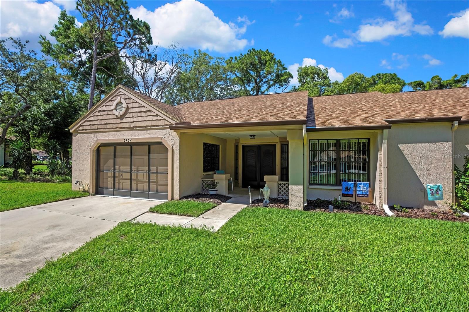 Beautiful move-in ready villa in Timber Pines! This 2-bedroom, 2-bath home with a 1.5-car garage offers an oversized driveway, charming covered front porch with vinyl ceiling, and laminate flooring throughout. Major updates include a roof replaced in June 2024, HVAC in August 2023, and enclosed lanai vinyl windows updated in 2018. The kitchen features granite countertops, wood cabinets, stainless steel appliances, an undermount sink, and a built-in pantry. The separate dining room includes built-in cabinetry with a granite counter, adding both storage and style. The primary suite offers a walk-in closet, slider access to the lanai, and an updated bathroom with a walk-in shower, granite vanity, undermount sink, and wood cabinetry. The secondary bathroom has also been updated with a new vanity, granite countertop, undermount sink, wood cabinets, tile flooring, and a tub/shower combo. Enjoy the covered enclosed lanai overlooking the private backyard. Located in Timber Pines, a premier 55+ gated golf community offering 4 golf courses, 2 clubhouses, pools, tennis, pickleball, fitness center, performing arts center, clubs, activities, and so much more. Absolutely move-in ready!